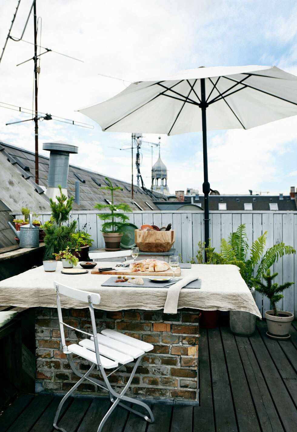 UTSIKT: På toppen av en bygård, med utsikt over byens tak og tårn, ligger denne oasen av en takterrasse. Eierne har valgt en rustikk look med materialer som tre, stein og mur. Bordplaten er lagt oppå en gammel, ubrukt skorstein. Små furu- og grantrær holder terrassen grønn hele året. FOTO: Christina Birch UTSIKT: På toppen av en bygård, med utsikt over byens tak og tårn, ligger denne oasen av en takterrasse. Eierne har valgt en rustikk look med materialer som tre, stein og mur. Bordplaten er lagt oppå en gammel, ubrukt skorstein. Små furu- og grantrær holder terrassen grønn hele året. FOTO: Christina Birch
