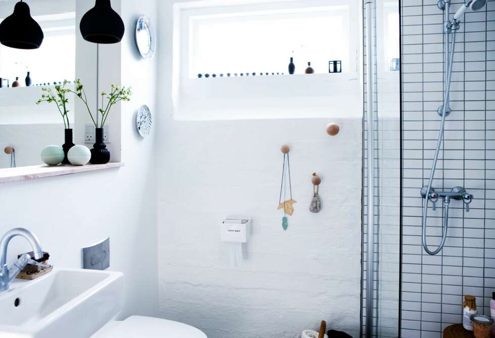 LUFTIG DUSJVEGG: Dusjveggen i glass hindrer gulvet i å bli vått og lar lyset spre seg på badet. Knaggene er fra helgo.dk. I vinduet har de pyntet med steiner de har samlet på. FOTO: Tia Borgsmidt LUFTIG DUSJVEGG: Dusjveggen i glass hindrer gulvet i å bli vått og lar lyset spre seg på badet. Knaggene er fra helgo.dk. I vinduet har de pyntet med steiner de har samlet på. FOTO: Tia Borgsmidt