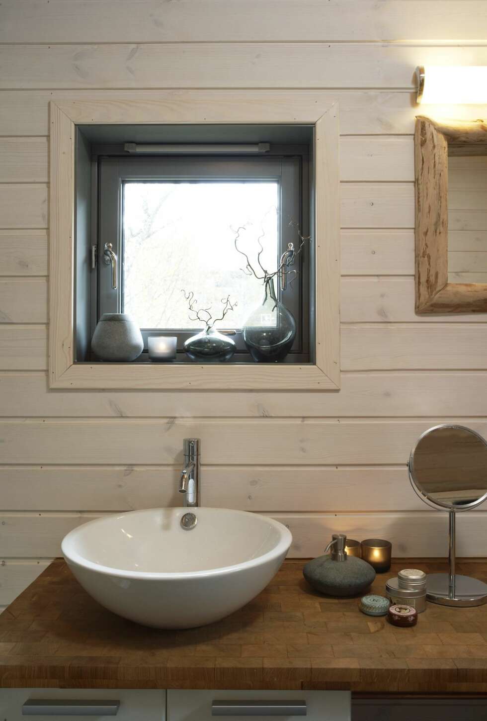 BADET: Badet ligger i den gamle delen av hytta. Materialvalget fra gulvet i den nye delen er videreført gjennom benkeplaten i endeved. Armatur fra Vola. BADET: Badet ligger i den gamle delen av hytta. Materialvalget fra gulvet i den nye delen er videreført gjennom benkeplaten i endeved. Armatur fra Vola.