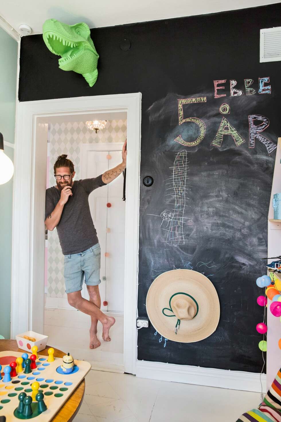LEKENT: - Det skal være lekent og fargerikt. Stilen fra barnerommene kan gjerne spre seg i hjemmet, mener Pär. Den ene veggen på sønnen Ebbes rom er malt med tavlemaling. Den grønne dinosauren er fra en vindusutstilling på H&M, der Lovisa jobber. FOTO: Jenny Brandt LEKENT: - Det skal være lekent og fargerikt. Stilen fra barnerommene kan gjerne spre seg i hjemmet, mener Pär. Den ene veggen på sønnen Ebbes rom er malt med tavlemaling. Den grønne dinosauren er fra en vindusutstilling på H&M, der Lovisa jobber. FOTO: Jenny Brandt
