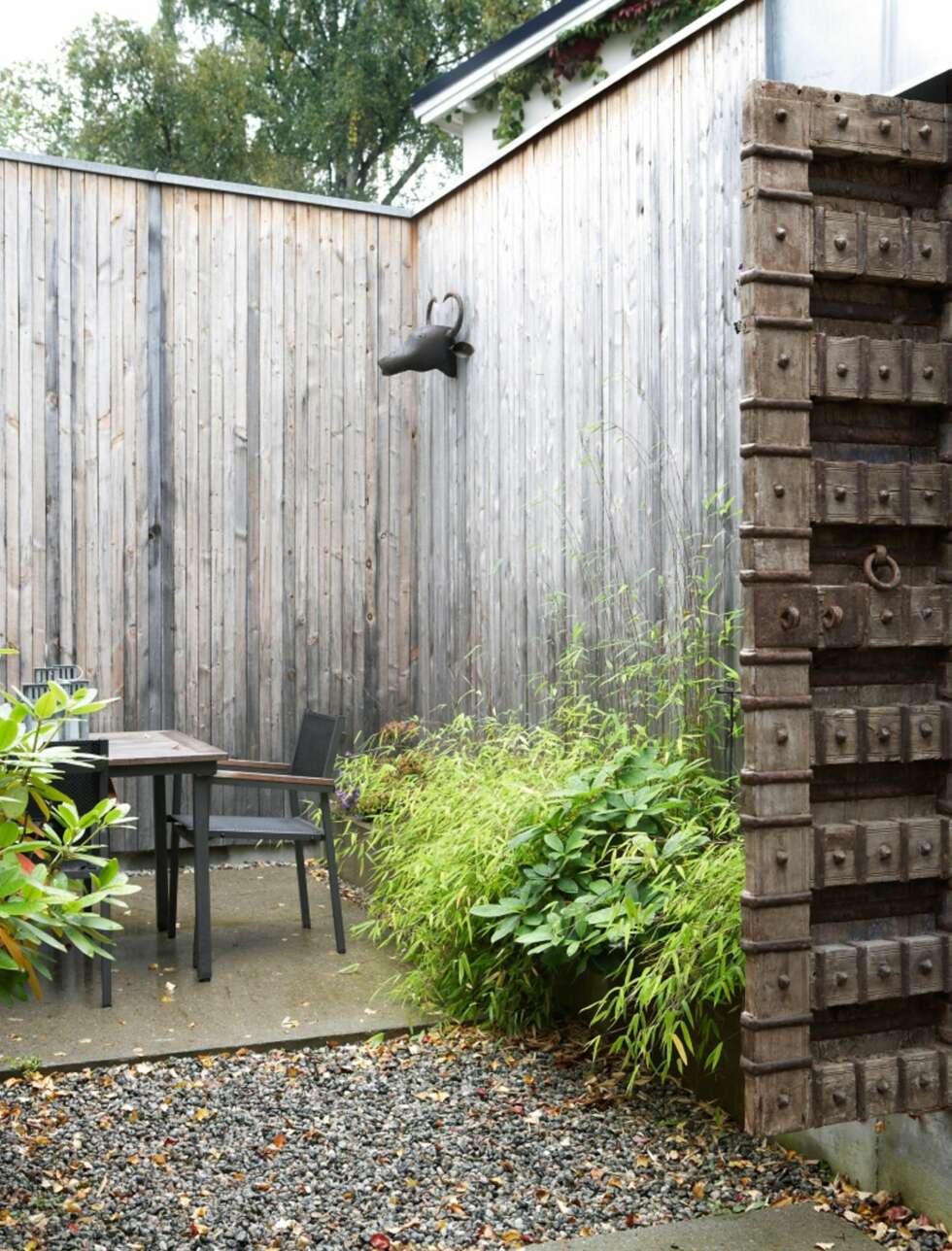 SOLID DØR: Tregjerdet rundt eiendommen er høyt og lukker boligen inne. Den solide døren som står åpen fører inn til huset og uterommene. SOLID DØR: Tregjerdet rundt eiendommen er høyt og lukker boligen inne. Den solide døren som står åpen fører inn til huset og uterommene.