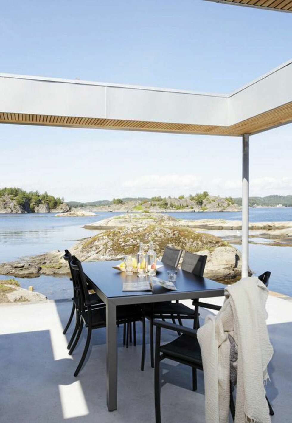 DUKET FOR UTELIV: Også fra terrassen på det nederste nivå er utsikten over vannet utmerket. De lette, elegante møblene er omtrent av samme type som de i spisestuen. DUKET FOR UTELIV: Også fra terrassen på det nederste nivå er utsikten over vannet utmerket. De lette, elegante møblene er omtrent av samme type som de i spisestuen.