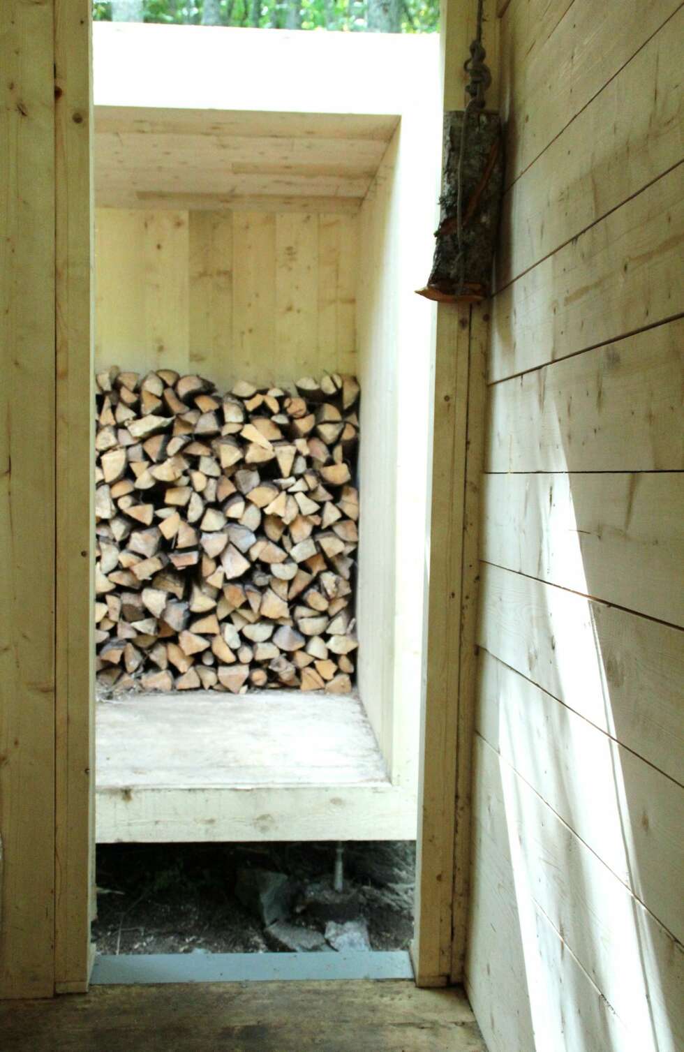 TILBYGG: Badstua er hevet over skogbunnen slik at du kan sitte på kanten av tilbygget og slappe av. Her lagres veden og du kan henge opp klær. TILBYGG: Badstua er hevet over skogbunnen slik at du kan sitte på kanten av tilbygget og slappe av. Her lagres veden og du kan henge opp klær.