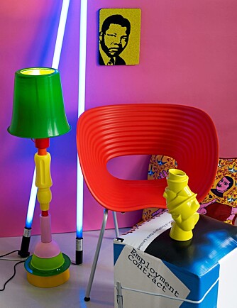 LEKEN: Lampe i resirkulert plast laget av kunstner Hearth Nash, kr 10.000, perlet bilde av en ung Nelson Mandela, kr 600, pute fra Afro Coffee, 50 x 50, kr 490, puff laget av reklamebannere, kr 1500, alt fra Isandi. Neonrør, kr 600/stk. fra Eske. Gul vase «Closely separated», kr 799, fra Illums Bolighus. «Tom Vac» stol i kunstmateriale, kr 2090, fra Verket Interiør. LEKEN: Lampe i resirkulert plast laget av kunstner Hearth Nash, kr 10.000, perlet bilde av en ung Nelson Mandela, kr 600, pute fra Afro Coffee, 50 x 50, kr 490, puff laget av reklamebannere, kr 1500, alt fra Isandi. Neonrør, kr 600/stk. fra Eske. Gul vase «Closely separated», kr 799, fra Illums Bolighus. «Tom Vac» stol i kunstmateriale, kr 2090, fra Verket Interiør.