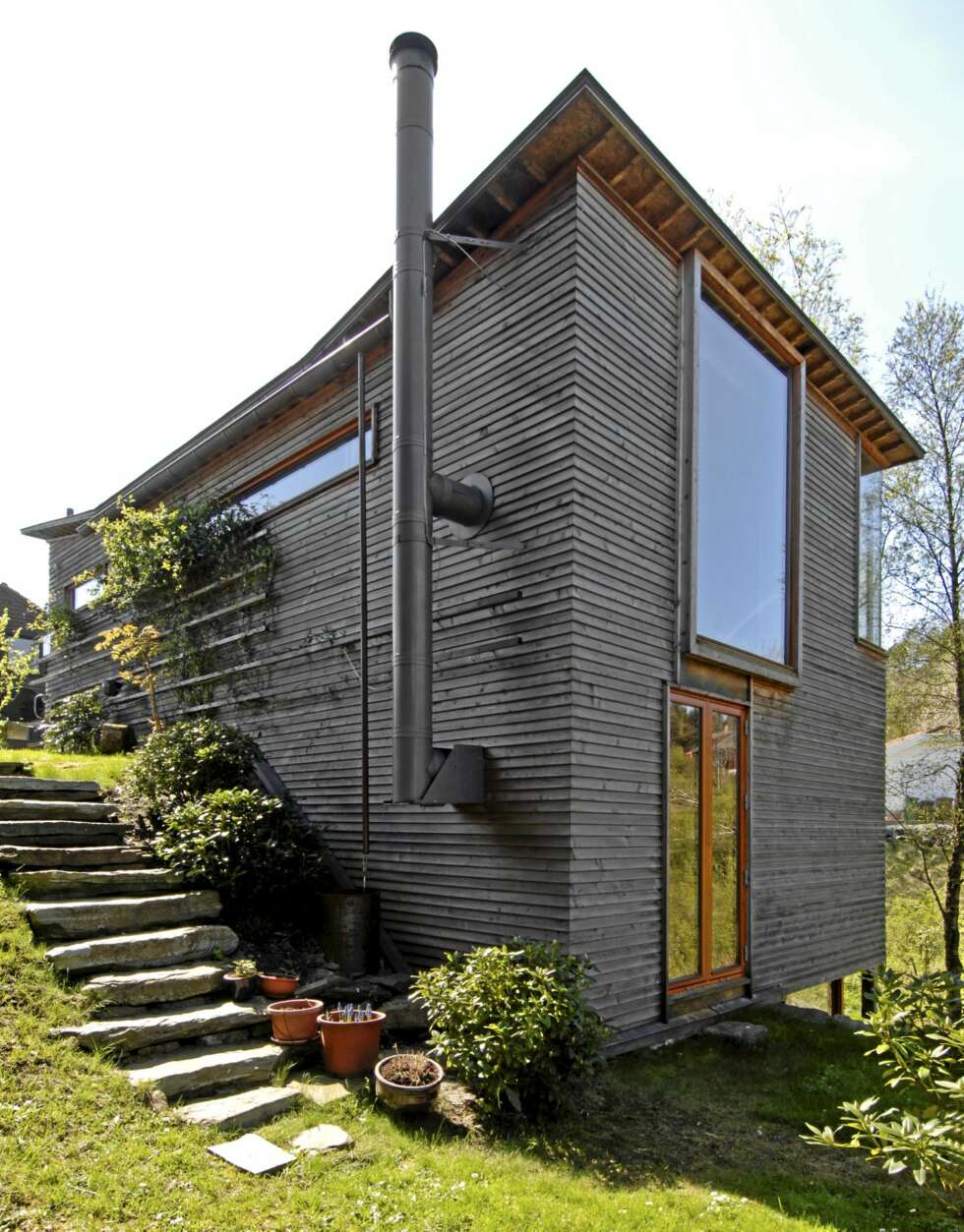 HØYREIST: Fra baksiden ser hvordan det delvis nedgravde huset reiser seg. Utvendig er det kledd med sibirsk lerk hele veien rundt. Kobbertaket heller, og det har kun en takrenne. HØYREIST: Fra baksiden ser hvordan det delvis nedgravde huset reiser seg. Utvendig er det kledd med sibirsk lerk hele veien rundt. Kobbertaket heller, og det har kun en takrenne.