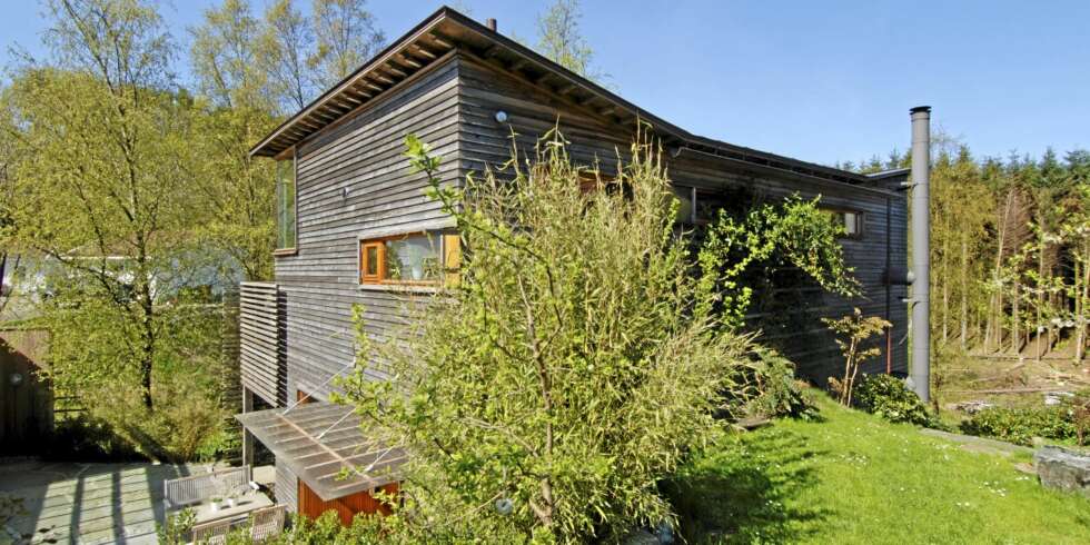 KULT MED SVAI I TAKET: Huset til arkitektene Hilde Haga og Rune Grov ligger nedgravd i en bratt skråning. Sibirsk lerk kler hele bygningen. Huset har bare en takrenne. Utenpåliggende pipe. KULT MED SVAI I TAKET: Huset til arkitektene Hilde Haga og Rune Grov ligger nedgravd i en bratt skråning. Sibirsk lerk kler hele bygningen. Huset har bare en takrenne. Utenpåliggende pipe.