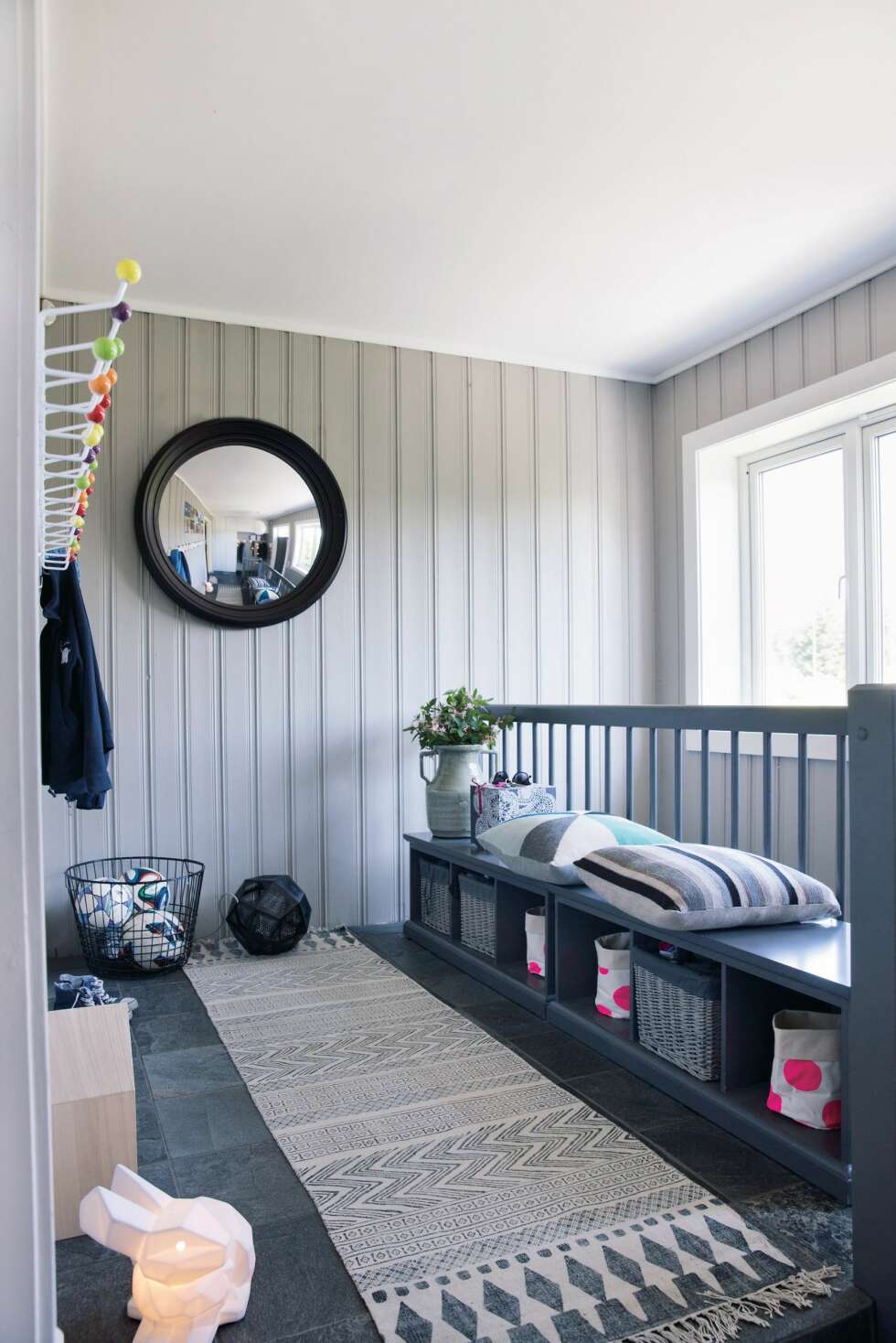 Fast plass. Smarte løsninger og gode materialvalg gjør barnefamiliens gang både åpen og bruksvennlig. Inngangspartiet har tre nivåer, øverste nivå er forbeholdt de tre aktive barna. Alt har sin plass. Under benken har de sine personlige kurver, og på veggen har de sine egne knagger. Benkene ble funnet på Skeidar. Veggfargen er Jotun Lady 10341 Kalk, mens gelenderet er malt med NCS-kode S-5000-N. Gulvlampe fra Tom Dixon, speil fra Eske, teppe og tøykurver med prikker fra Bolina. Puter og kaninlampe fra Eske. Styling Tone Kroken. Fast plass. Smarte løsninger og gode materialvalg gjør barnefamiliens gang både åpen og bruksvennlig. Inngangspartiet har tre nivåer, øverste nivå er forbeholdt de tre aktive barna. Alt har sin plass. Under benken har de sine personlige kurver, og på veggen har de sine egne knagger. Benkene ble funnet på Skeidar. Veggfargen er Jotun Lady 10341 Kalk, mens gelenderet er malt med NCS-kode S-5000-N. Gulvlampe fra Tom Dixon, speil fra Eske, teppe og tøykurver med prikker fra Bolina. Puter og kaninlampe fra Eske. Styling Tone Kroken.