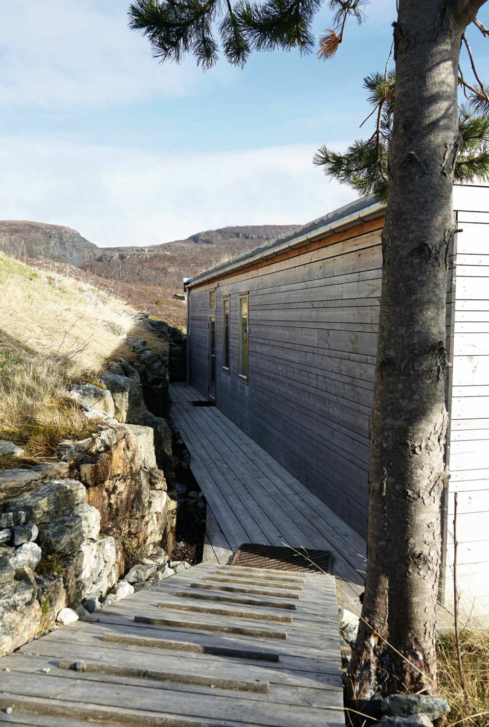 INNGANG I LE: Mye vær kommer på kort varsel. Ankomsten og inngangsdøren til kysthuset er klokt nok trukket inn mot bergveggen. INNGANG I LE: Mye vær kommer på kort varsel. Ankomsten og inngangsdøren til kysthuset er klokt nok trukket inn mot bergveggen.