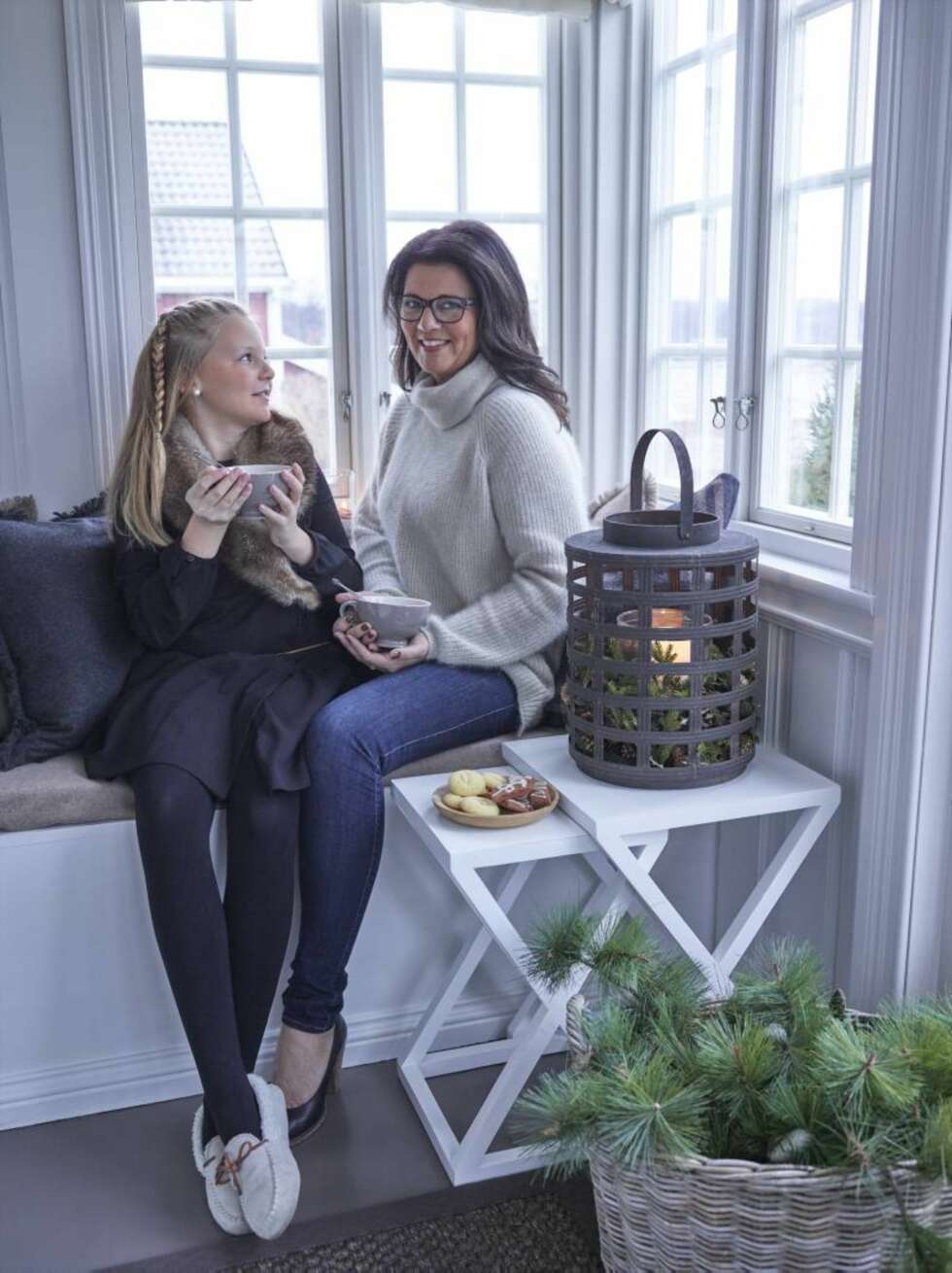 Kosekrok. Berit og datteren Anne Sophie på en av favorittplassene i huset, glassverandaen i første etasje. – Det er ekstra fint å sitte her med en bok når regner pisker på vinduene, sier Berit. Bordet og lykten er fra PB Home, kurven fra Artwood og puten fra Lama. Kosekrok. Berit og datteren Anne Sophie på en av favorittplassene i huset, glassverandaen i første etasje. – Det er ekstra fint å sitte her med en bok når regner pisker på vinduene, sier Berit. Bordet og lykten er fra PB Home, kurven fra Artwood og puten fra Lama.