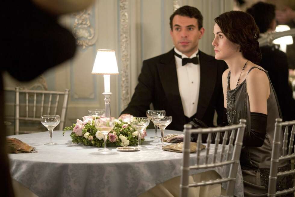 Lady Mary (Michelle Dockery) og hennes kavaler drikker champagne av elegante glass i krystall. Lady Mary (Michelle Dockery) og hennes kavaler drikker champagne av elegante glass i krystall.