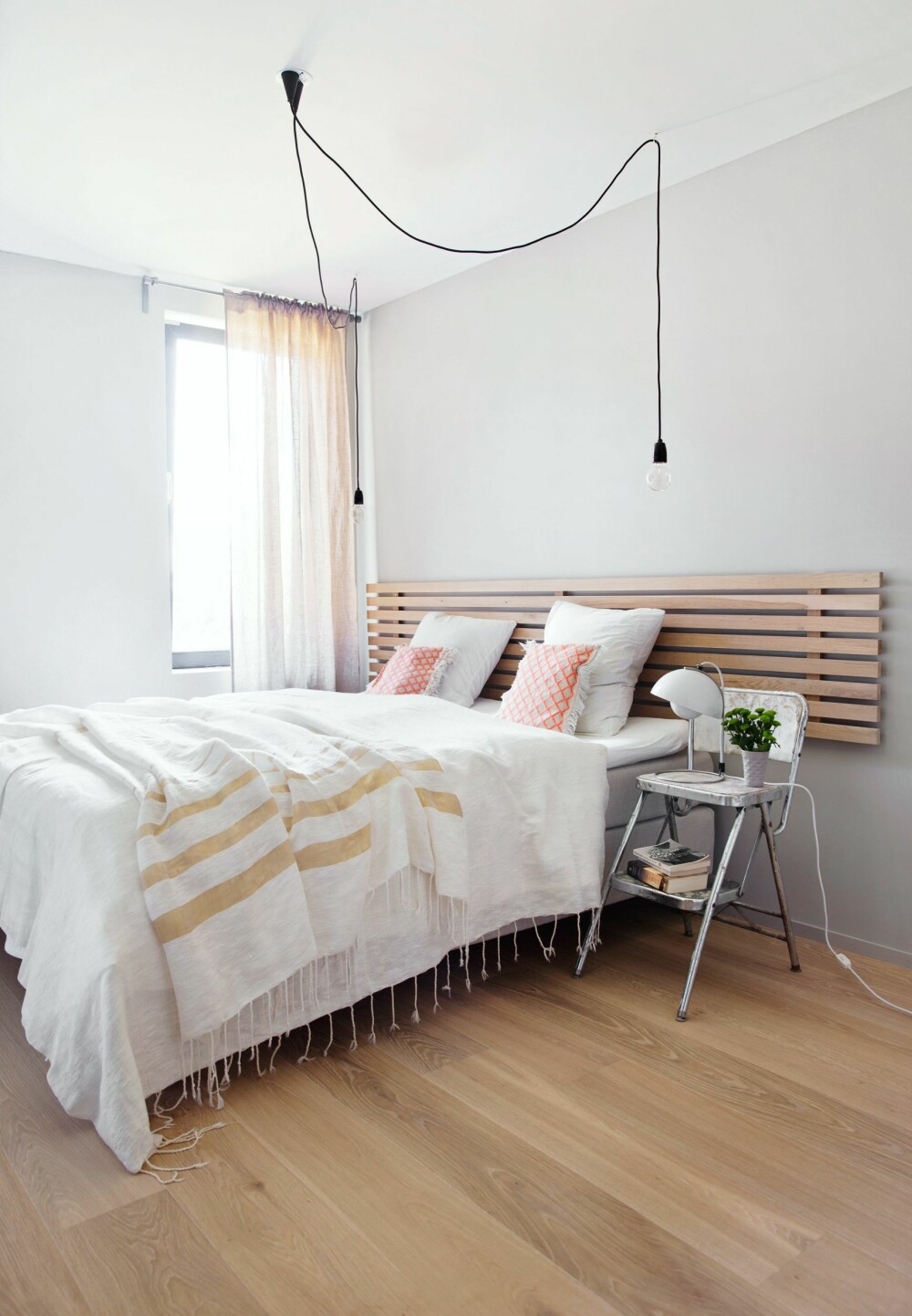 ENKELT OG ELEGANT: To svarte, nakne pærer fra Muuto understreker rommets enkle karakter. Veggfargen heter Skumring og er brukt på samtlige vegger i huset.
– I mitt forrige hjem var alle vegger helhvite, så akkurat det er jeg vaksinert mot. Denne gråfargen er nøytral som hvitt, men mye lunere. Hodegjerdet er satt sammen av åtte enkle spiler, mellomrommene er akkurat brede nok til å kile inn en bok der, slik har den praktisk funksjon utover det vanlige. Sengetøy, teppe og puter er fra Heges egen nettbutikk, cosa.no. Tekstilene er håndvevde fra Tunisia og Marokko, kvinnene som lager dem får sin del av fortjenesten. Lampen på nattbordet er designet av Verner Panton. ENKELT OG ELEGANT: To svarte, nakne pærer fra Muuto understreker rommets enkle karakter. Veggfargen heter Skumring og er brukt på samtlige vegger i huset.
– I mitt forrige hjem var alle vegger helhvite, så akkurat det er jeg vaksinert mot. Denne gråfargen er nøytral som hvitt, men mye lunere. Hodegjerdet er satt sammen av åtte enkle spiler, mellomrommene er akkurat brede nok til å kile inn en bok der, slik har den praktisk funksjon utover det vanlige. Sengetøy, teppe og puter er fra Heges egen nettbutikk, cosa.no. Tekstilene er håndvevde fra Tunisia og Marokko, kvinnene som lager dem får sin del av fortjenesten. Lampen på nattbordet er designet av Verner Panton.