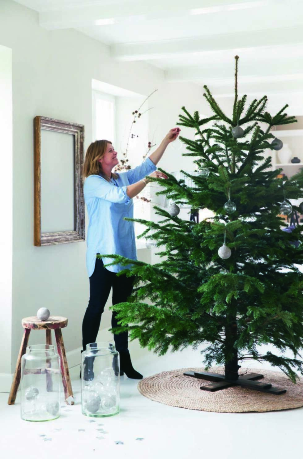 Pynteglad. Julepynten hentes frem i slutten av november, men treet pyntes først tre-fire dager før jul. Og på selve julaften settes de levende lysene på. Juletrefoten er selvlagd, og teppet i jute er fra egen kolleksjon. – På julaften flytter vi treet fra veggen og ut på gulvet, og da kan vi bare dra i teppet når vi skal flytte det, sier Tine. Rammen som henger på veggen er fra Suzanne Warning, og det hender en vakker stjernegirlander får henge inni rammen. Styling: Tone Kroken. Pynteglad. Julepynten hentes frem i slutten av november, men treet pyntes først tre-fire dager før jul. Og på selve julaften settes de levende lysene på. Juletrefoten er selvlagd, og teppet i jute er fra egen kolleksjon. – På julaften flytter vi treet fra veggen og ut på gulvet, og da kan vi bare dra i teppet når vi skal flytte det, sier Tine. Rammen som henger på veggen er fra Suzanne Warning, og det hender en vakker stjernegirlander får henge inni rammen. Styling: Tone Kroken.