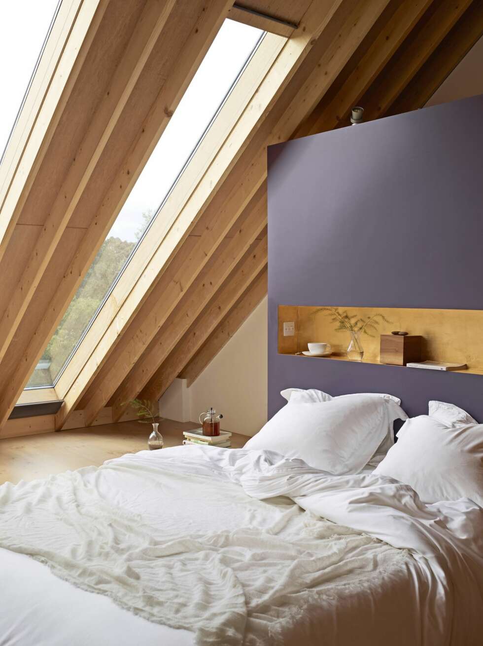 Fargen på sengegavlen heter Twilight Cinders 1/s0rb09087, og er fra leverandøren Dulux. Vinduene er fra Roofglaze.co.uk. I nisjen i sengegavlen er det lagt inn lysbryter og dimmefunksjon til alt lys i rommet. Her styres også de elektriske rullegardinene. Det er ikke synlig på bildet, men det er montert uplights i gulvet nær der skråtaket starter, noe som øker romfølelsen. Bøker fungerer som nattbord. Tekannen er fra Menu, en julegave til paret fra Maris mor. Styling: Tone Kroken. Fargen på sengegavlen heter Twilight Cinders 1/s0rb09087, og er fra leverandøren Dulux. Vinduene er fra Roofglaze.co.uk. I nisjen i sengegavlen er det lagt inn lysbryter og dimmefunksjon til alt lys i rommet. Her styres også de elektriske rullegardinene. Det er ikke synlig på bildet, men det er montert uplights i gulvet nær der skråtaket starter, noe som øker romfølelsen. Bøker fungerer som nattbord. Tekannen er fra Menu, en julegave til paret fra Maris mor. Styling: Tone Kroken.