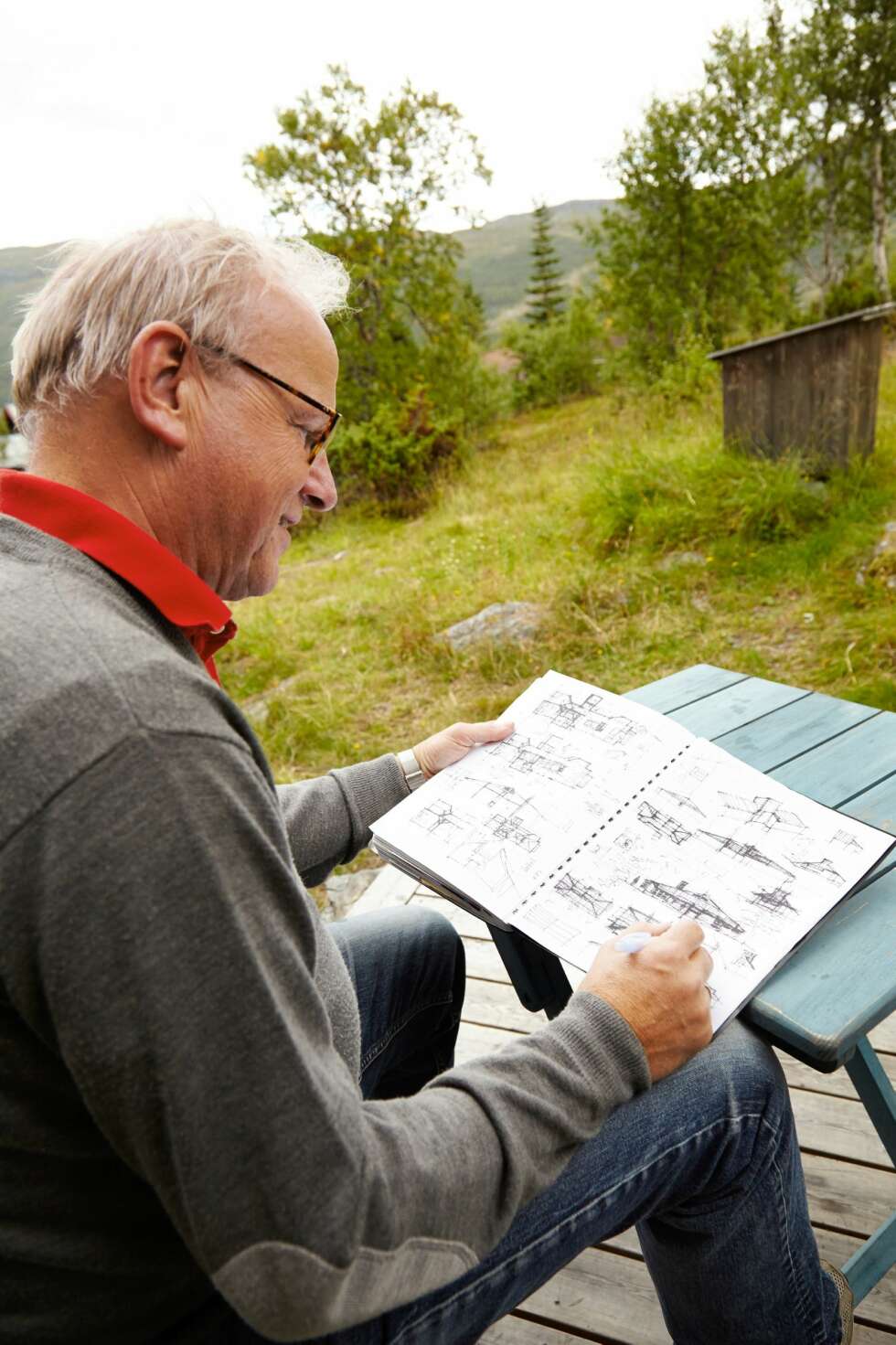 KREATIV PROSESS: Hytteeier og arkitekt Ragnar Osnes har
brukt mye tid for å komme frem til en optimal planløsning.
Her viser han frem noen av de første skissene. Foto: Per Erik Jæger KREATIV PROSESS: Hytteeier og arkitekt Ragnar Osnes har
brukt mye tid for å komme frem til en optimal planløsning.
Her viser han frem noen av de første skissene. Foto: Per Erik Jæger