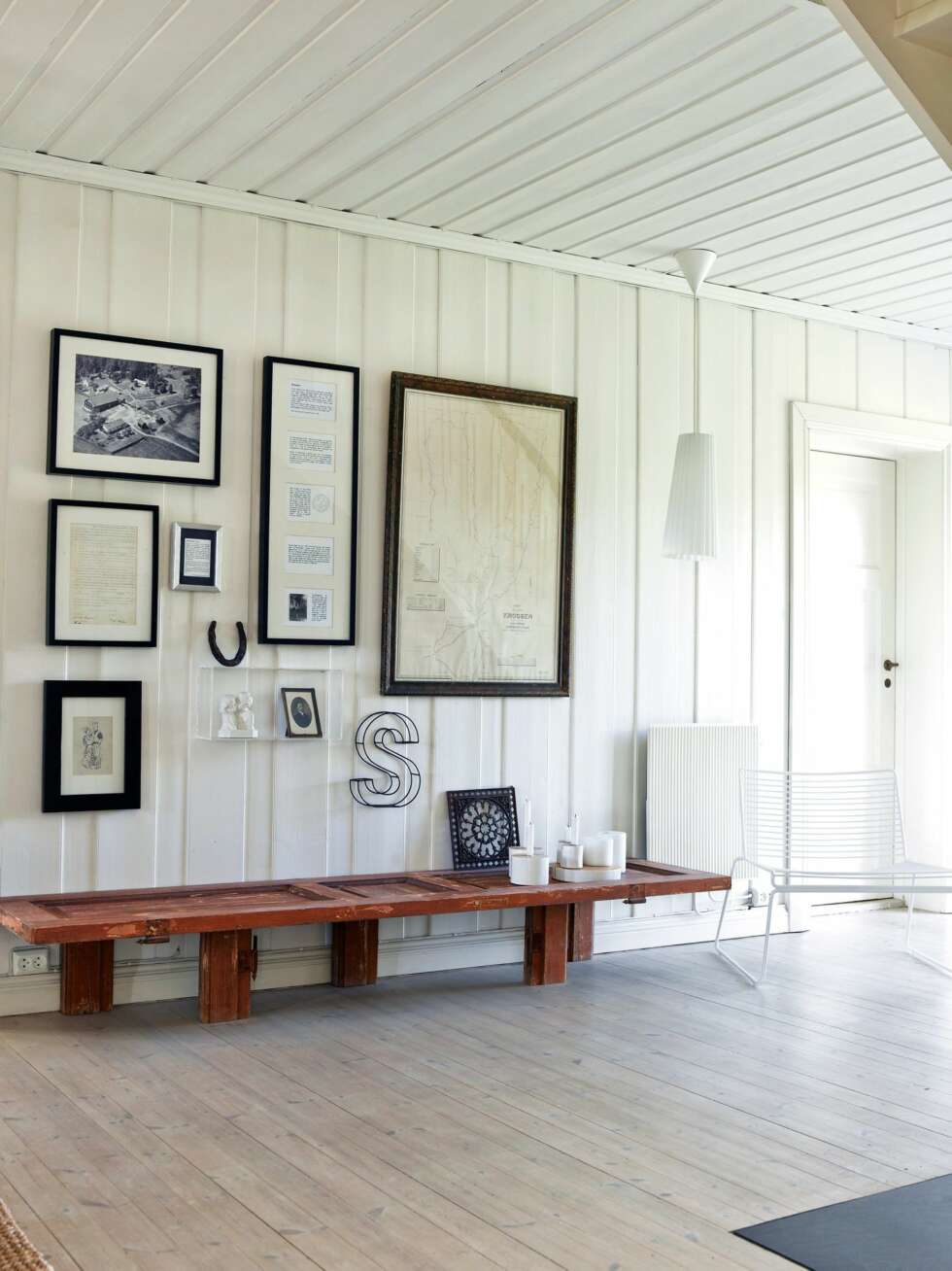 GÅRDSHISTORIE: I hallen står en benk laget av den gamle inngangsdøren på gården. På veggen bak henger gamle bilder, kart, en kontrakt og gårdsgjenstander. Styling: Kirsten Visdal. GÅRDSHISTORIE: I hallen står en benk laget av den gamle inngangsdøren på gården. På veggen bak henger gamle bilder, kart, en kontrakt og gårdsgjenstander. Styling: Kirsten Visdal.