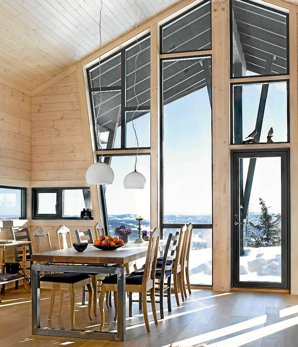 SPEKTAKULÆR UTSIKT: Mot sør har hytteeierne en fantastisk utsikt helt til Tryvannstårnet i Oslo, om de bruker kikkert. I oppholdsommene tegnet arkitekten store vinduer ned til gulvet og opp i mønet slik at familien kunne få mest mulig ut av lyset og utsikten. Det nye og moderne spisebordet er egendesignet og benkeplaten er laget av en lokal møbelsnekker. Den består av massiv heltre eikeplank som har blitt importert fra USA. SPEKTAKULÆR UTSIKT: Mot sør har hytteeierne en fantastisk utsikt helt til Tryvannstårnet i Oslo, om de bruker kikkert. I oppholdsommene tegnet arkitekten store vinduer ned til gulvet og opp i mønet slik at familien kunne få mest mulig ut av lyset og utsikten. Det nye og moderne spisebordet er egendesignet og benkeplaten er laget av en lokal møbelsnekker. Den består av massiv heltre eikeplank som har blitt importert fra USA.