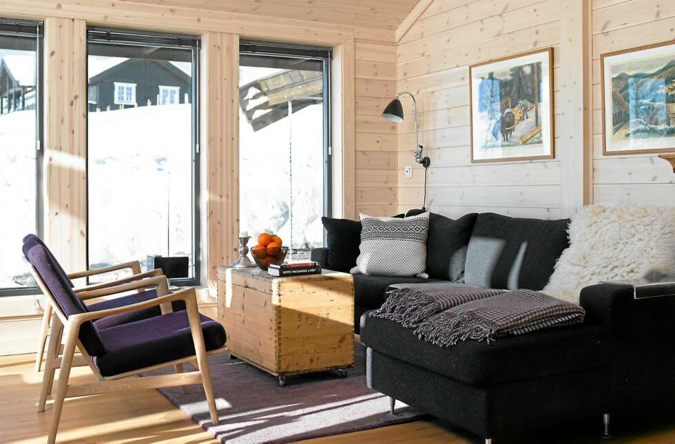 STRAM STUE: Hytteeierne har innredet med stilrene møbler. Både sofaen og teppet er fra Bolia. Den gamle kisten har de satt hjul på, mens stolene, som eierne hadde fra før, har blitt trukket om i det danske ullstoffet Luna. Det samme stoffet er brukt på spisestuestolene. STRAM STUE: Hytteeierne har innredet med stilrene møbler. Både sofaen og teppet er fra Bolia. Den gamle kisten har de satt hjul på, mens stolene, som eierne hadde fra før, har blitt trukket om i det danske ullstoffet Luna. Det samme stoffet er brukt på spisestuestolene.