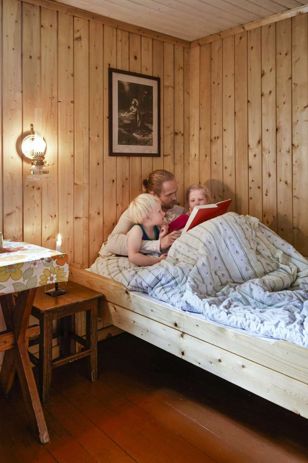 FAST INNSLAG: Det er like stor stas hver eneste kveld når Gunnar legger seg for å lese høyt fra eventyrboken for barna Boas og Naomi. Sengen er plassert rett ved kjøkkenbenken, som skiller de to sovesonene i hytta. (FOTO: Sveinung Bråthen) FAST INNSLAG: Det er like stor stas hver eneste kveld når Gunnar legger seg for å lese høyt fra eventyrboken for barna Boas og Naomi. Sengen er plassert rett ved kjøkkenbenken, som skiller de to sovesonene i hytta. (FOTO: Sveinung Bråthen)