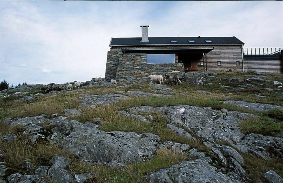 EN HERLIG MATERIALMIKS: Steinhuset på Baløy i Austrheim kommune er tegnet av arkitekt Tor Helge Valen. Her ser du hvordan fasaden et satt sammen av grå skiferstein, glass og et tjærebredd trepanel. Fra garasjen er det direkte inngang til huset. EN HERLIG MATERIALMIKS: Steinhuset på Baløy i Austrheim kommune er tegnet av arkitekt Tor Helge Valen. Her ser du hvordan fasaden et satt sammen av grå skiferstein, glass og et tjærebredd trepanel. Fra garasjen er det direkte inngang til huset.