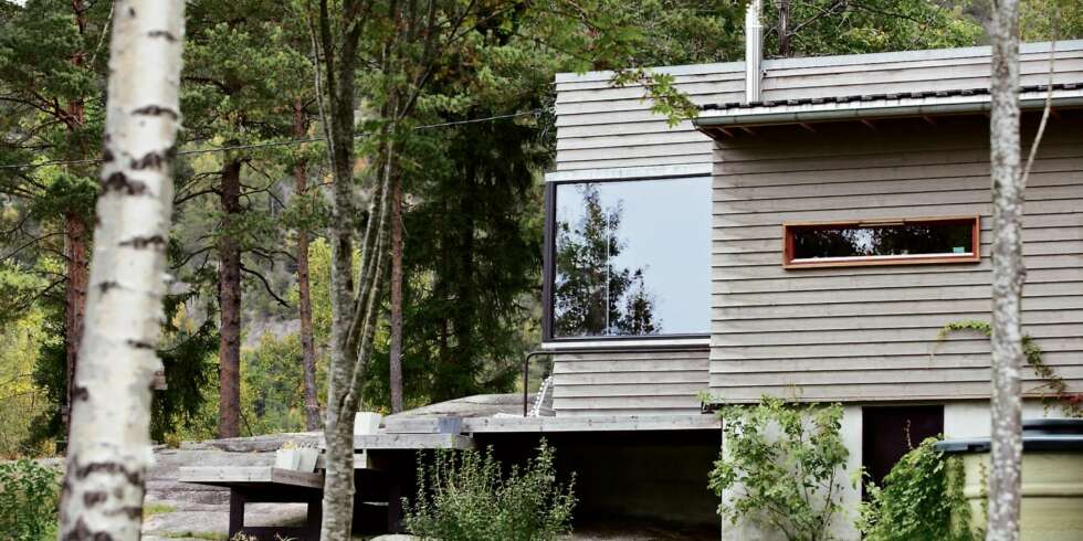 ARKITEKTUR OG NATUR: Terrasser og plattinger er brukt for å koble hytta og landskapet tettere sammen. Bjelkene under terrassen er malt i svart for å skape skygge og en svevende følelse. ARKITEKTUR OG NATUR: Terrasser og plattinger er brukt for å koble hytta og landskapet tettere sammen. Bjelkene under terrassen er malt i svart for å skape skygge og en svevende følelse.