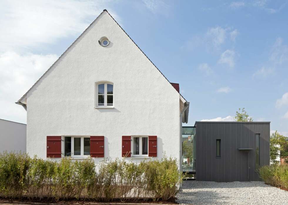 VISUELL KRYMPNG. Ved å male fasaden på tilbygget sort, samt å benytte stående kledning og smale vinduer, ønsket arkitekten å krympe tilbygget visuelt sett. VISUELL KRYMPNG. Ved å male fasaden på tilbygget sort, samt å benytte stående kledning og smale vinduer, ønsket arkitekten å krympe tilbygget visuelt sett.