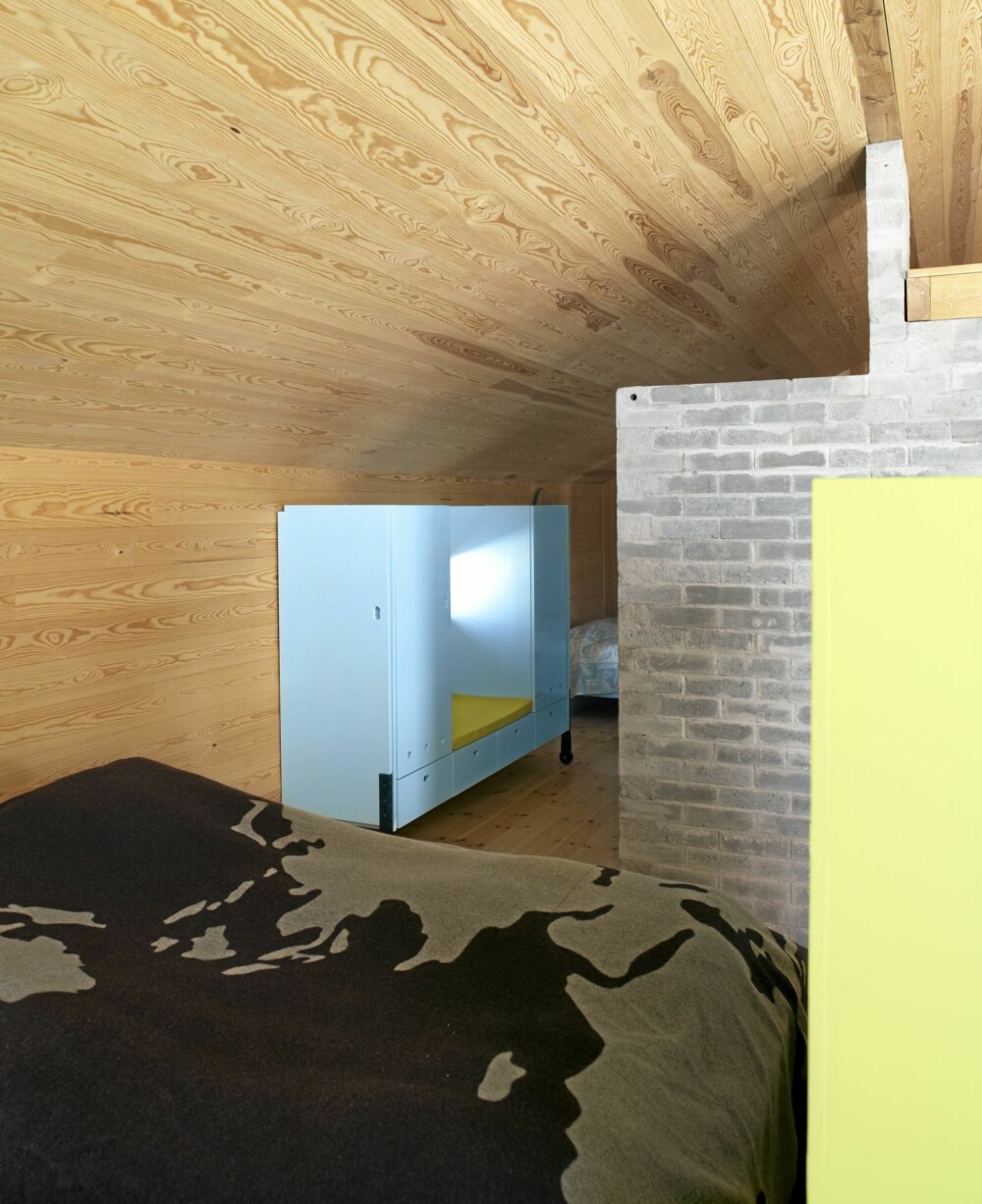KUL OG KOMPAKT: Soveplassen ligger diskre plassert bak peisblokken. I dette området ligger også et bad skjermet av murvegger. Fargene stammer fra arkitektenes spesielle fargekart. KUL OG KOMPAKT: Soveplassen ligger diskre plassert bak peisblokken. I dette området ligger også et bad skjermet av murvegger. Fargene stammer fra arkitektenes spesielle fargekart.