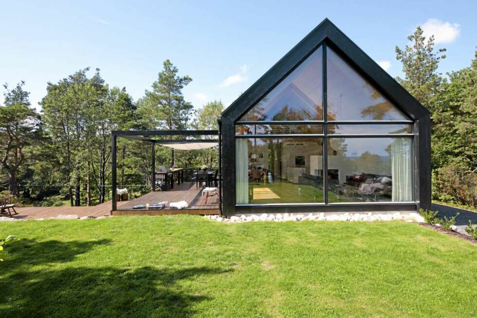 GRAFISK RENHET: Hytta tegnet av arkitekt Cecilie Wille er renskrapet og nesten grafisk i formuttrykket. Megaterrassen til venstre er et yndet uterom hele sommeren. GRAFISK RENHET: Hytta tegnet av arkitekt Cecilie Wille er renskrapet og nesten grafisk i formuttrykket. Megaterrassen til venstre er et yndet uterom hele sommeren.
