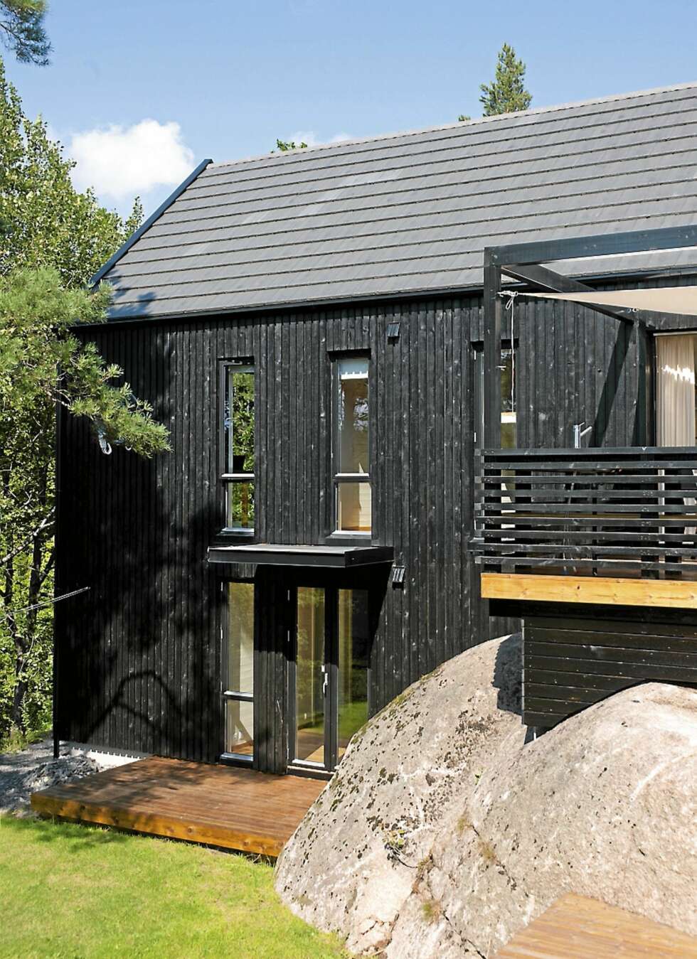 TRIPP-TRAPP: Hytta er plassert på den minst attraktive delen av tomten og her ser du hvordan hytta trapper seg av nedover i terrenget. Høye, smale vinduer, nesten som skyteskår slipper strimer av lys inn i huset. TRIPP-TRAPP: Hytta er plassert på den minst attraktive delen av tomten og her ser du hvordan hytta trapper seg av nedover i terrenget. Høye, smale vinduer, nesten som skyteskår slipper strimer av lys inn i huset.