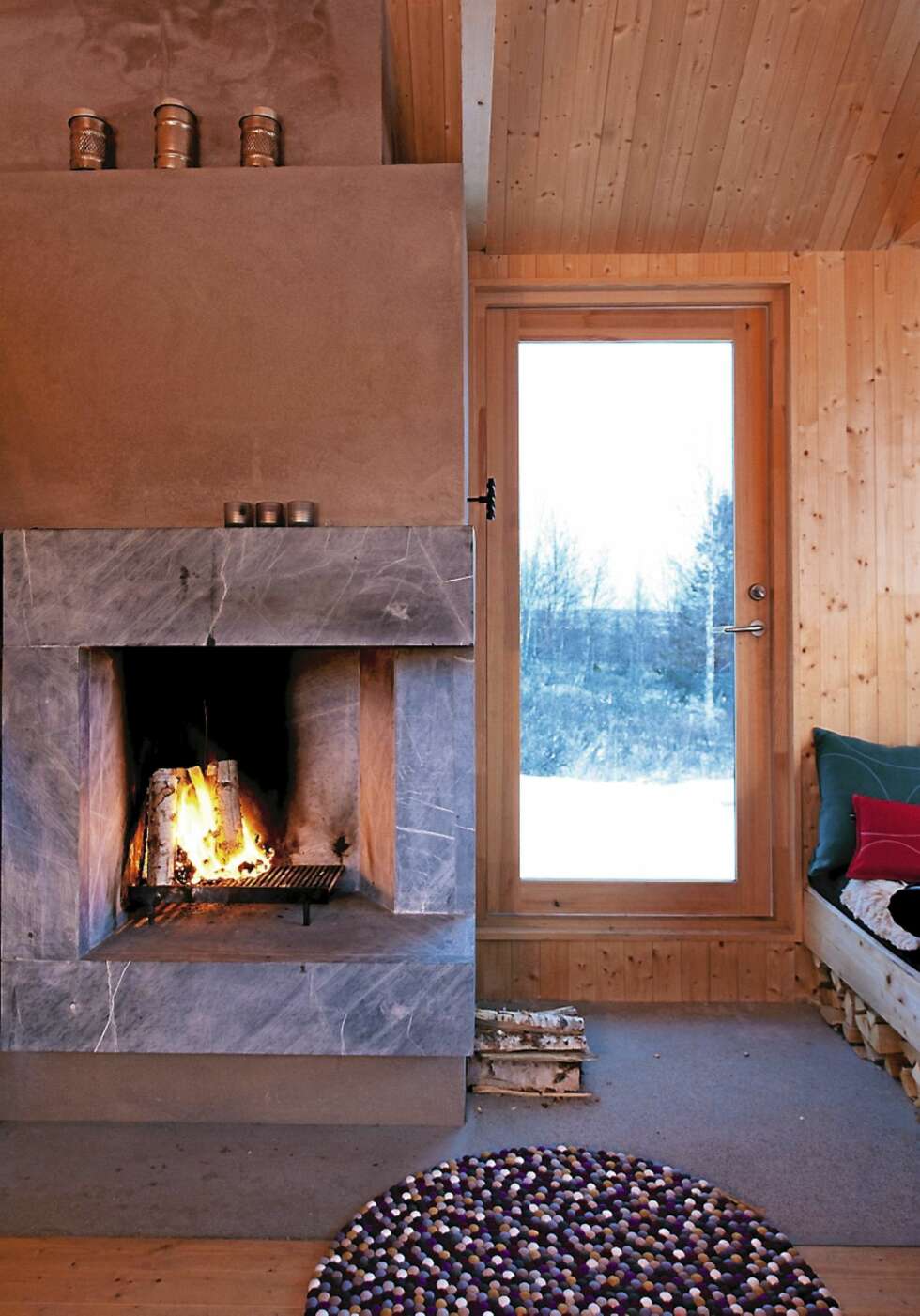 SAMSPILL: Som resten av hytta er den arkitekttegnete peisen enkel og renlinjet. SAMSPILL: Som resten av hytta er den arkitekttegnete peisen enkel og renlinjet.
