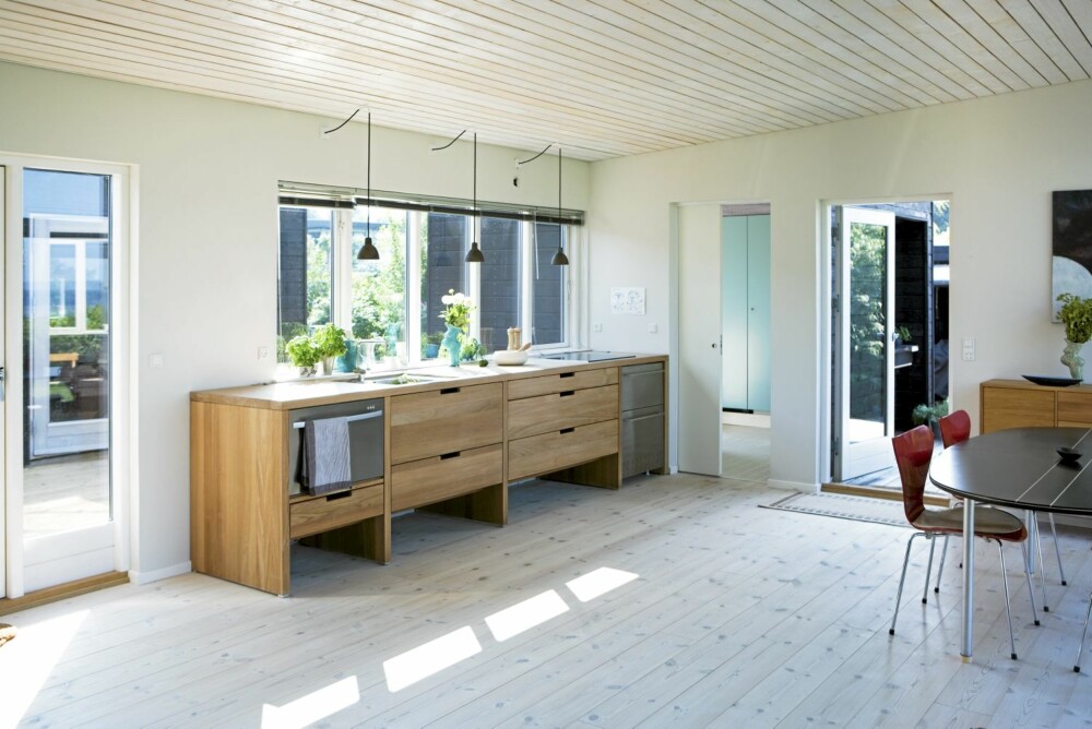 ÅPEN KJØKKENLØSNING: I allrommet er det kjøkken og spisebord i den ene enden og stue i den andre. For at kjøkkenet ikke skulle bli for dominerende, har den danske arkitekten Knud Kapper i Hansen Kitchen tegnet en innredning på mål. Alle skapene er underskap i nøytral stil. ÅPEN KJØKKENLØSNING: I allrommet er det kjøkken og spisebord i den ene enden og stue i den andre. For at kjøkkenet ikke skulle bli for dominerende, har den danske arkitekten Knud Kapper i Hansen Kitchen tegnet en innredning på mål. Alle skapene er underskap i nøytral stil.