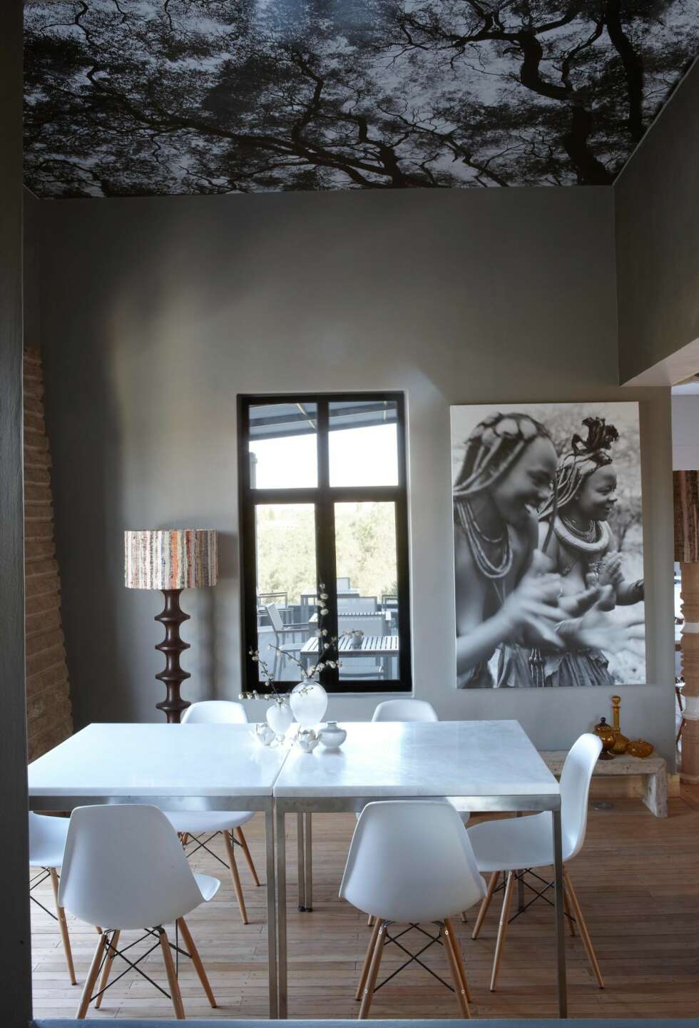 TAKTAPET: I restauranten er taket tapetsert med et svart-hvitt bilde av et tre. Fotograf er Micky Hoyle. På veggen henger et annet av bildene hans. Enkle bord med marmorplater er omgitt av gjenkjennelige DSWstoler med understell i tre, designet av ekteparet Eames. TAKTAPET: I restauranten er taket tapetsert med et svart-hvitt bilde av et tre. Fotograf er Micky Hoyle. På veggen henger et annet av bildene hans. Enkle bord med marmorplater er omgitt av gjenkjennelige DSWstoler med understell i tre, designet av ekteparet Eames.