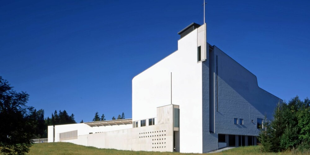 VARDÅSEN KIRKE: Bygningens dominerende og fremste symbolbærende element er klokketårnet samt en buet frontvegg. VARDÅSEN KIRKE: Bygningens dominerende og fremste symbolbærende element er klokketårnet samt en buet frontvegg.