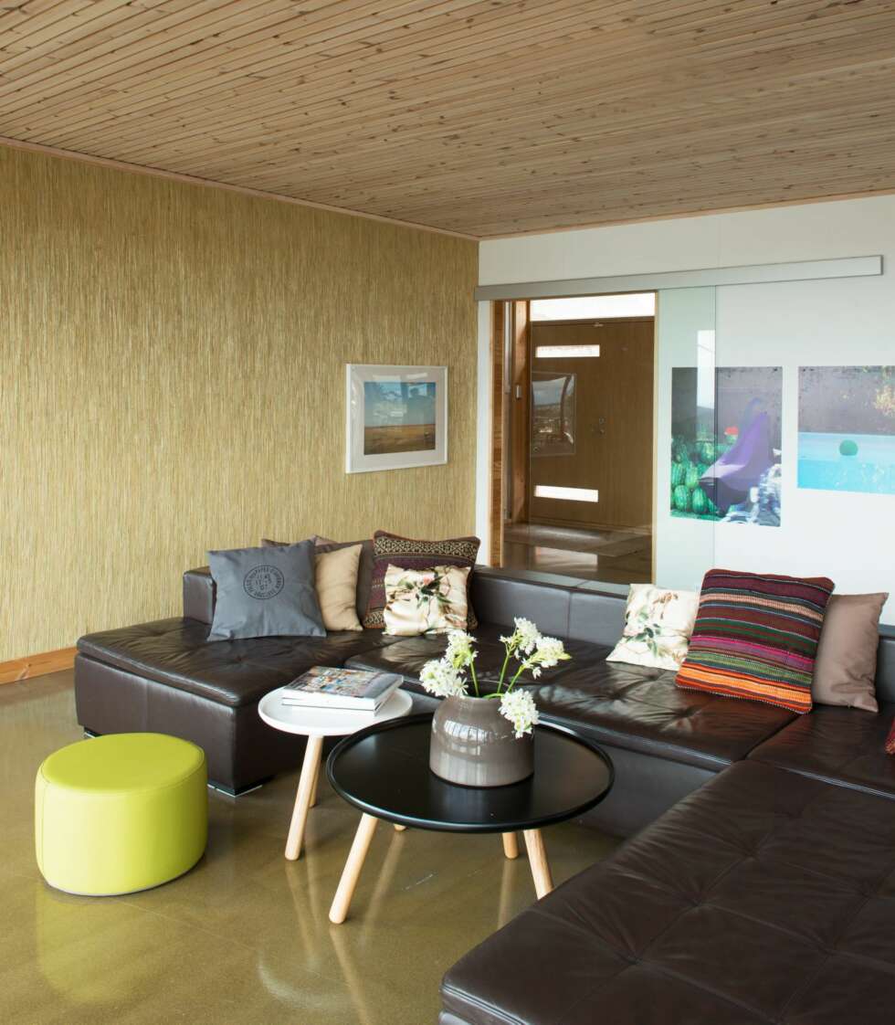 BETONG, GRAN OG STRÅTAPET: Stuesonen i allrommet vender mot utsikten. Sofaen er fra BoConcept, sofabordene fra Normann Copenhagen, puffen fra Sundays Design. BETONG, GRAN OG STRÅTAPET: Stuesonen i allrommet vender mot utsikten. Sofaen er fra BoConcept, sofabordene fra Normann Copenhagen, puffen fra Sundays Design.