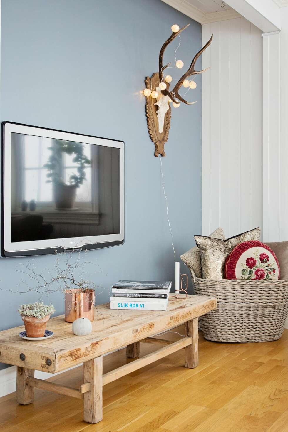 VAKKERT HJØRNE: Det antikke bordet i kinesisk eik skaper hygge under tv-skjermen. Dyrekraniet er et bruktkupp som hun ga 300 kroner for. Både benken og putene i kurven er fra butikken Zanz. FOTO: Jorunn Tharaldsen VAKKERT HJØRNE: Det antikke bordet i kinesisk eik skaper hygge under tv-skjermen. Dyrekraniet er et bruktkupp som hun ga 300 kroner for. Både benken og putene i kurven er fra butikken Zanz. FOTO: Jorunn Tharaldsen
