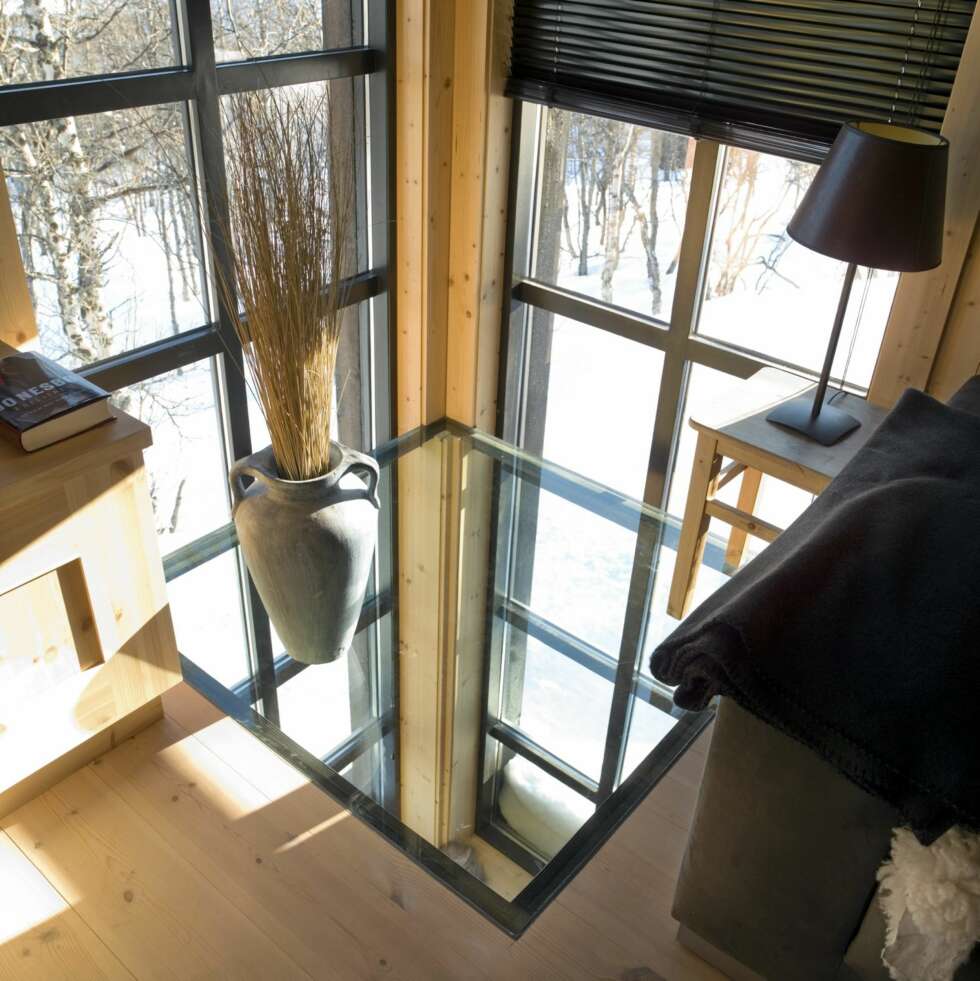 ET PANORAMA GLASSHJØRNE: Med glass i både vegger og gulv åpnes forbindelsen mellom de to etasjene i hytta. Du ser også rett ut på bjørkeskogen like utenfor hytta. ET PANORAMA GLASSHJØRNE: Med glass i både vegger og gulv åpnes forbindelsen mellom de to etasjene i hytta. Du ser også rett ut på bjørkeskogen like utenfor hytta.