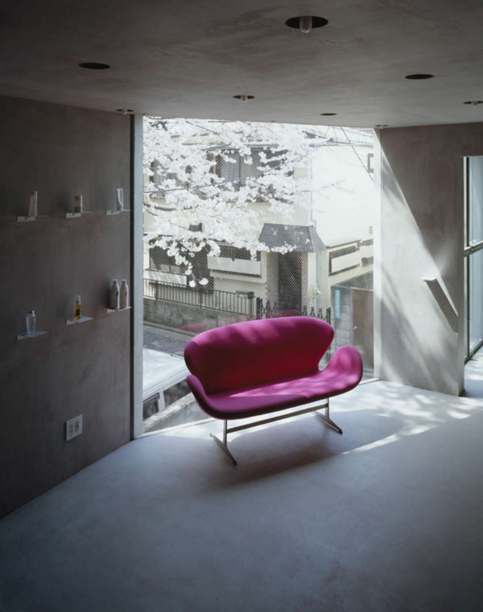 FARGEKLATT: En knall rosa sofa fungerer som en fargeklatt i det ellers nakne interiøret. FARGEKLATT: En knall rosa sofa fungerer som en fargeklatt i det ellers nakne interiøret.