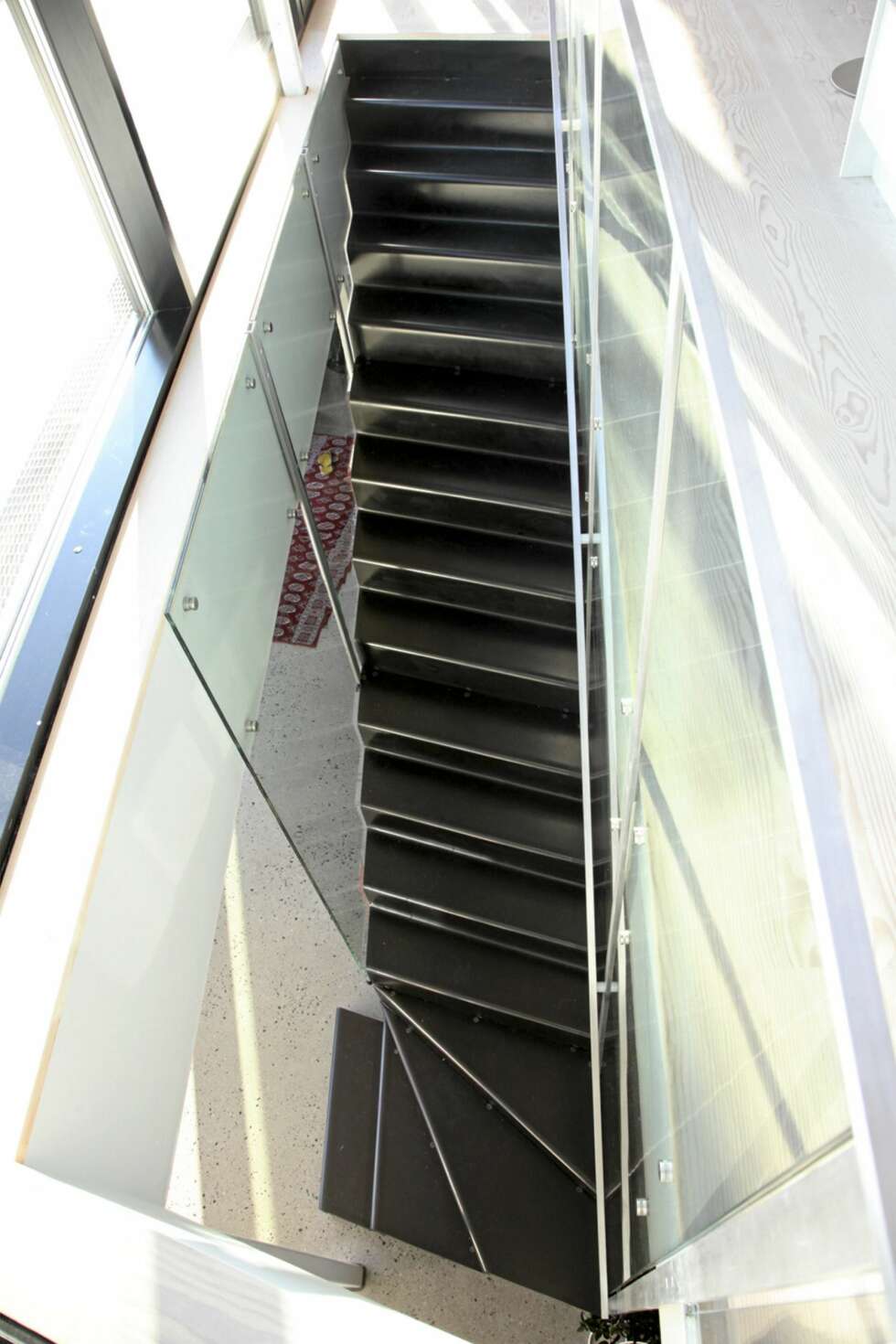 LETT OG ELEGANT: Trappen er formet som et moderne møbel mellom de to nederste etasjene. LETT OG ELEGANT: Trappen er formet som et moderne møbel mellom de to nederste etasjene.
