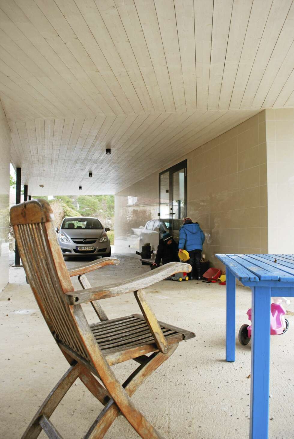ET LOGISK HUS: Bilen kjøres rett inn under huset, og herfra er det kort vei til gangen og trappen opp til annen etasje. Legg merke til de lyse, blanke flisene på veggene. ET LOGISK HUS: Bilen kjøres rett inn under huset, og herfra er det kort vei til gangen og trappen opp til annen etasje. Legg merke til de lyse, blanke flisene på veggene.