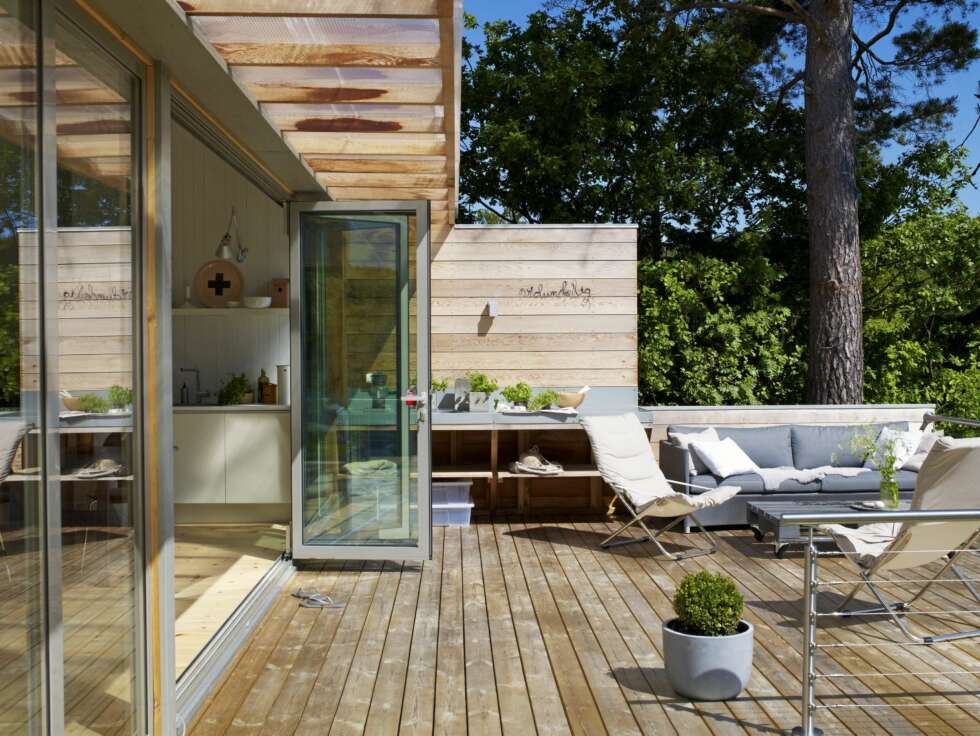 TERRASSE: I forlengelsen av kjøkkenbenken inne er det laget en arbeids-/avlastningsbenk ute, kledd i sink. Den polstrete utesofaen Diamond fra Cane-Line/Skeidar kan stå ute i alle slags vær. Bordet har Kari Janne laget av en europall. Stolene Fiesta fra Fiam er kjøpt hos Hus & Hage. TERRASSE: I forlengelsen av kjøkkenbenken inne er det laget en arbeids-/avlastningsbenk ute, kledd i sink. Den polstrete utesofaen Diamond fra Cane-Line/Skeidar kan stå ute i alle slags vær. Bordet har Kari Janne laget av en europall. Stolene Fiesta fra Fiam er kjøpt hos Hus & Hage.