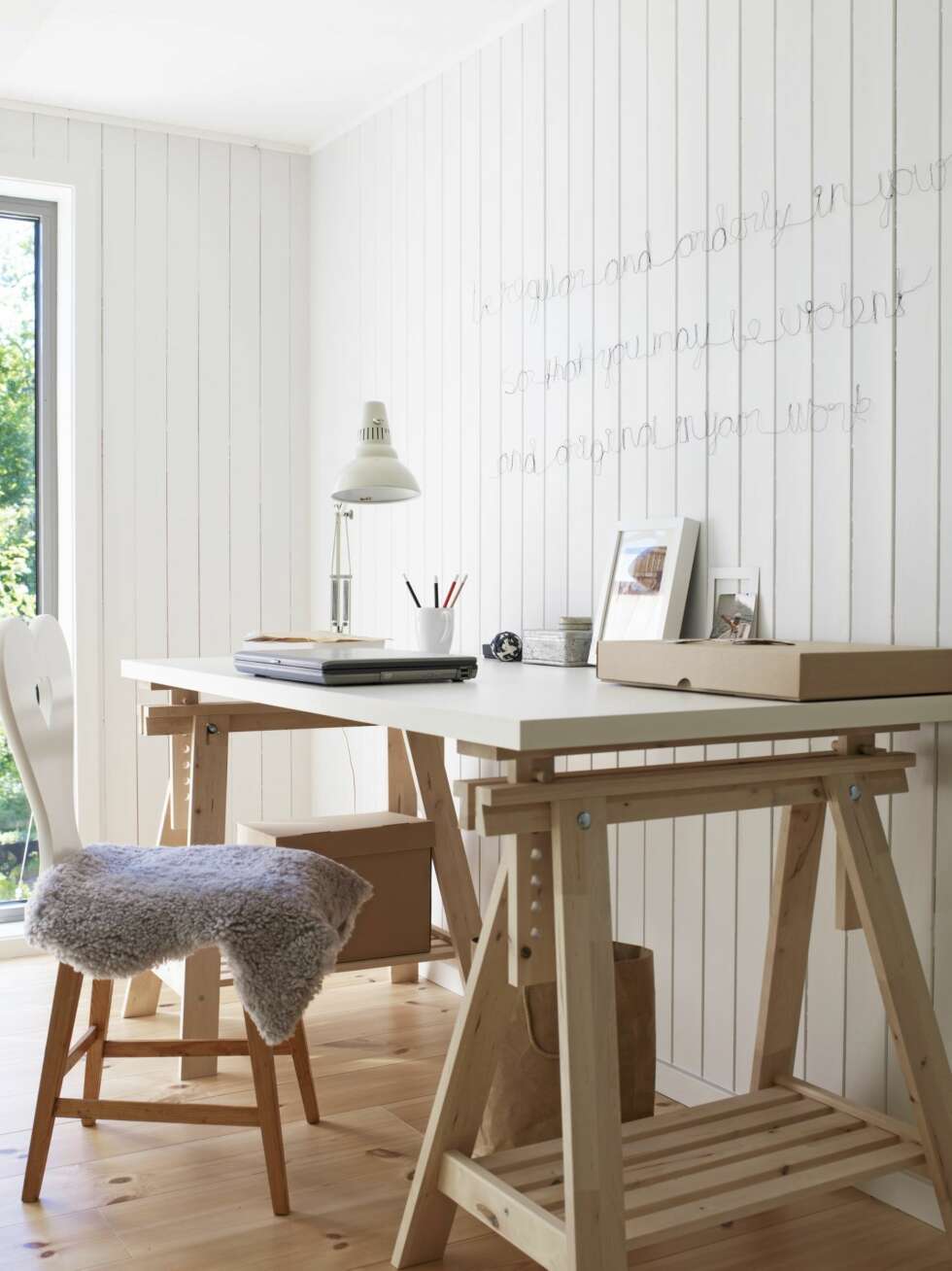KONTOR: På hemsen har de fått plass til et lite kontor. Det kan de også følge med på hva som skjer nedenunder. Bordplaten og beina er fra Ikea, den gamle Veluxlampen er kjøpt på finn.no, og hjertestolene sto i gamlehytta. På veggen har Kari Janne skrevet med ståltråd: Be regular and orderly in your life so that you may be violent and original in your work. Veggene er malt med Light Moonstone Flügger 311013. KONTOR: På hemsen har de fått plass til et lite kontor. Det kan de også følge med på hva som skjer nedenunder. Bordplaten og beina er fra Ikea, den gamle Veluxlampen er kjøpt på finn.no, og hjertestolene sto i gamlehytta. På veggen har Kari Janne skrevet med ståltråd: Be regular and orderly in your life so that you may be violent and original in your work. Veggene er malt med Light Moonstone Flügger 311013.