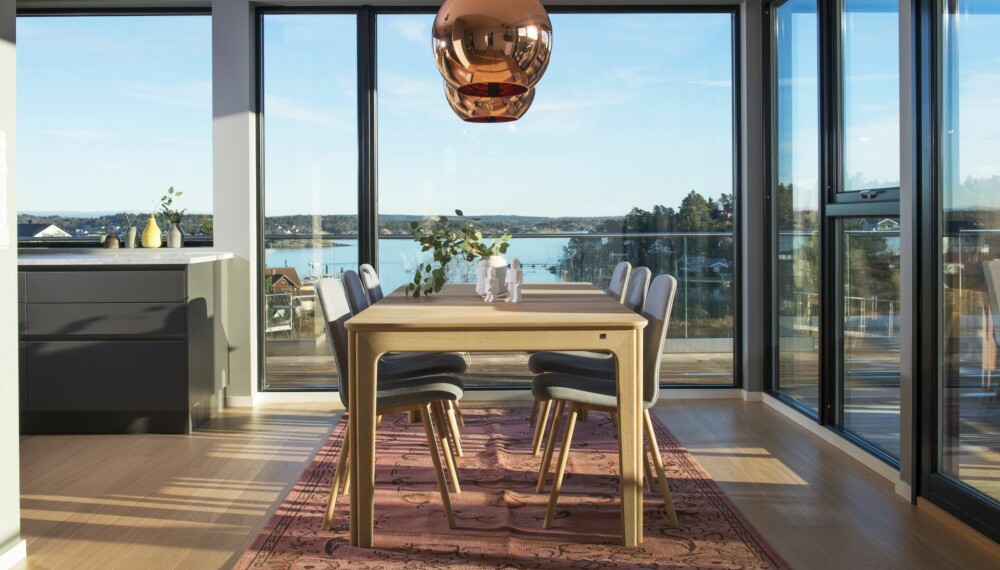 FANTASTISK UTSIKT: Spisestuen har fantastisk utsikt over Lahellefjorden. Til høyre er det skyvedører ut til den 100 kvadratmeter store terrassen, som strekker seg rundt hele huset. Spisebordet og stolene er fra danske Skovby. Gulvteppet er håndknyttet i Marokko og kjøpt hos Eske. Lampene er modellen Copper Shade fra Tom Dixon. Alle vinduene i huset har svarte karmer i stedet for hvite. FANTASTISK UTSIKT: Spisestuen har fantastisk utsikt over Lahellefjorden. Til høyre er det skyvedører ut til den 100 kvadratmeter store terrassen, som strekker seg rundt hele huset. Spisebordet og stolene er fra danske Skovby. Gulvteppet er håndknyttet i Marokko og kjøpt hos Eske. Lampene er modellen Copper Shade fra Tom Dixon. Alle vinduene i huset har svarte karmer i stedet for hvite.