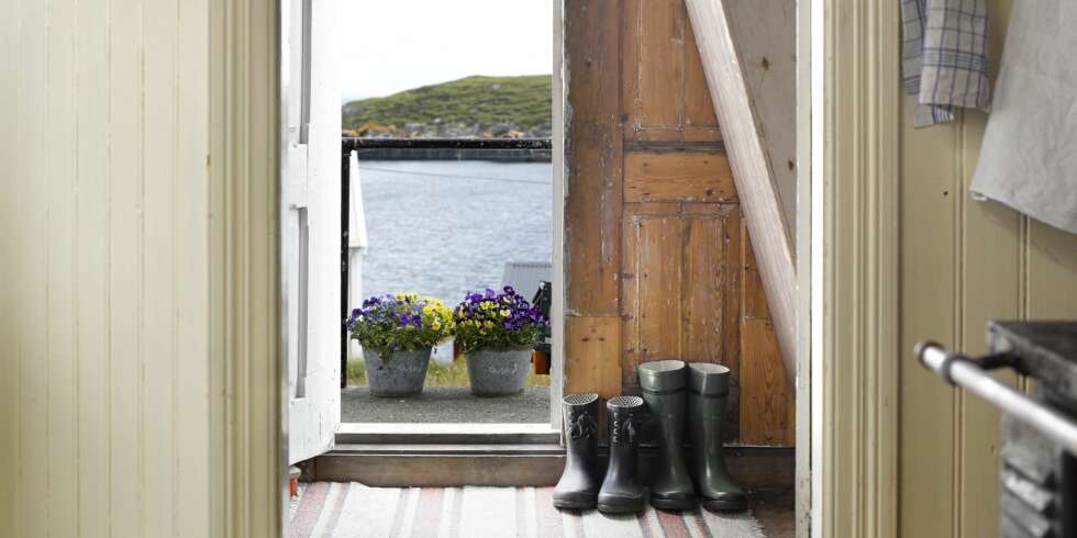 NORDØYAN: Fra trappa kommer man rett inn i kjøkkenet via et lite vindfang som også leder inn til stua. Vi skjønner godt at døra får stå åpen for å slippe inn utsikten mot sjøen. Legg merke til den bratte trappa. Ikke akkurat livsløpsstandard! Fargene er originale. NORDØYAN: Fra trappa kommer man rett inn i kjøkkenet via et lite vindfang som også leder inn til stua. Vi skjønner godt at døra får stå åpen for å slippe inn utsikten mot sjøen. Legg merke til den bratte trappa. Ikke akkurat livsløpsstandard! Fargene er originale.