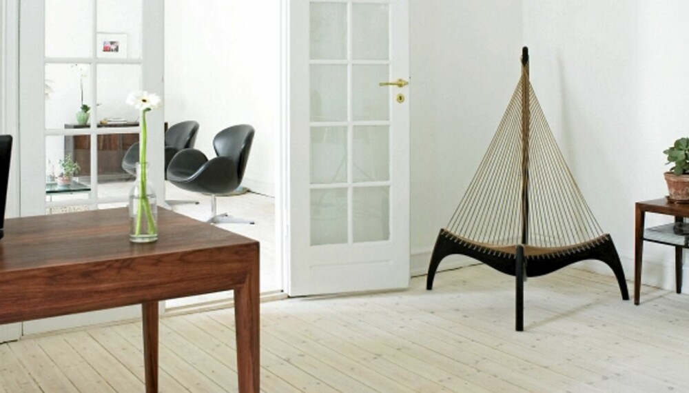 KJØLIG ELEGANSE: Lutede nåletregulv, hvite vegger og moderne danske klassikere i palisander er typiske trekk. Stolen "Harpen" er deisnget av Jørgen Høvelskov. KJØLIG ELEGANSE: Lutede nåletregulv, hvite vegger og moderne danske klassikere i palisander er typiske trekk. Stolen "Harpen" er deisnget av Jørgen Høvelskov.