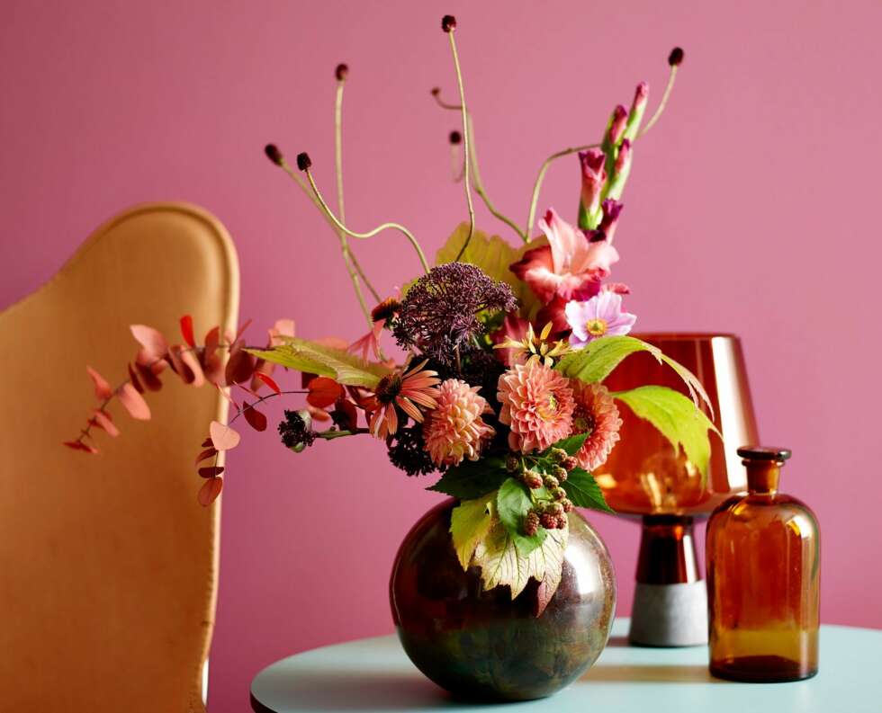 FARGERIKE BLOMSTER: Et supert triks om du ikke er like vågal og går for rosa farger i stuen, er å friske opp hjemmet med fargerike blomster. - Jeg elsker blomster! Det deilige er at de kan settes sammen i alle varianter. Til jul hadde jeg oransje roser og kongler. Sammen med den oransjee kanten på serviset ble det akkurat passe jul. (Farge: St. Paulia FR 2504.) FARGERIKE BLOMSTER: Et supert triks om du ikke er like vågal og går for rosa farger i stuen, er å friske opp hjemmet med fargerike blomster. - Jeg elsker blomster! Det deilige er at de kan settes sammen i alle varianter. Til jul hadde jeg oransje roser og kongler. Sammen med den oransjee kanten på serviset ble det akkurat passe jul. (Farge: St. Paulia FR 2504.)