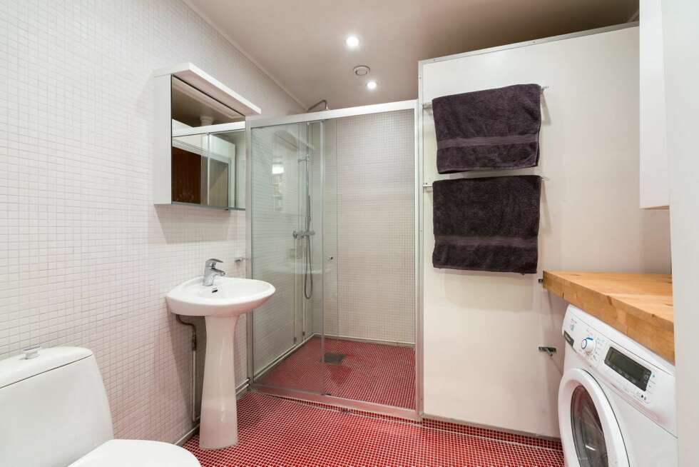 BAD: På badet har arkitekten brukt dusjveggen til håndkleoppheng og plassert vaskemaskinen under benken. BAD: På badet har arkitekten brukt dusjveggen til håndkleoppheng og plassert vaskemaskinen under benken.