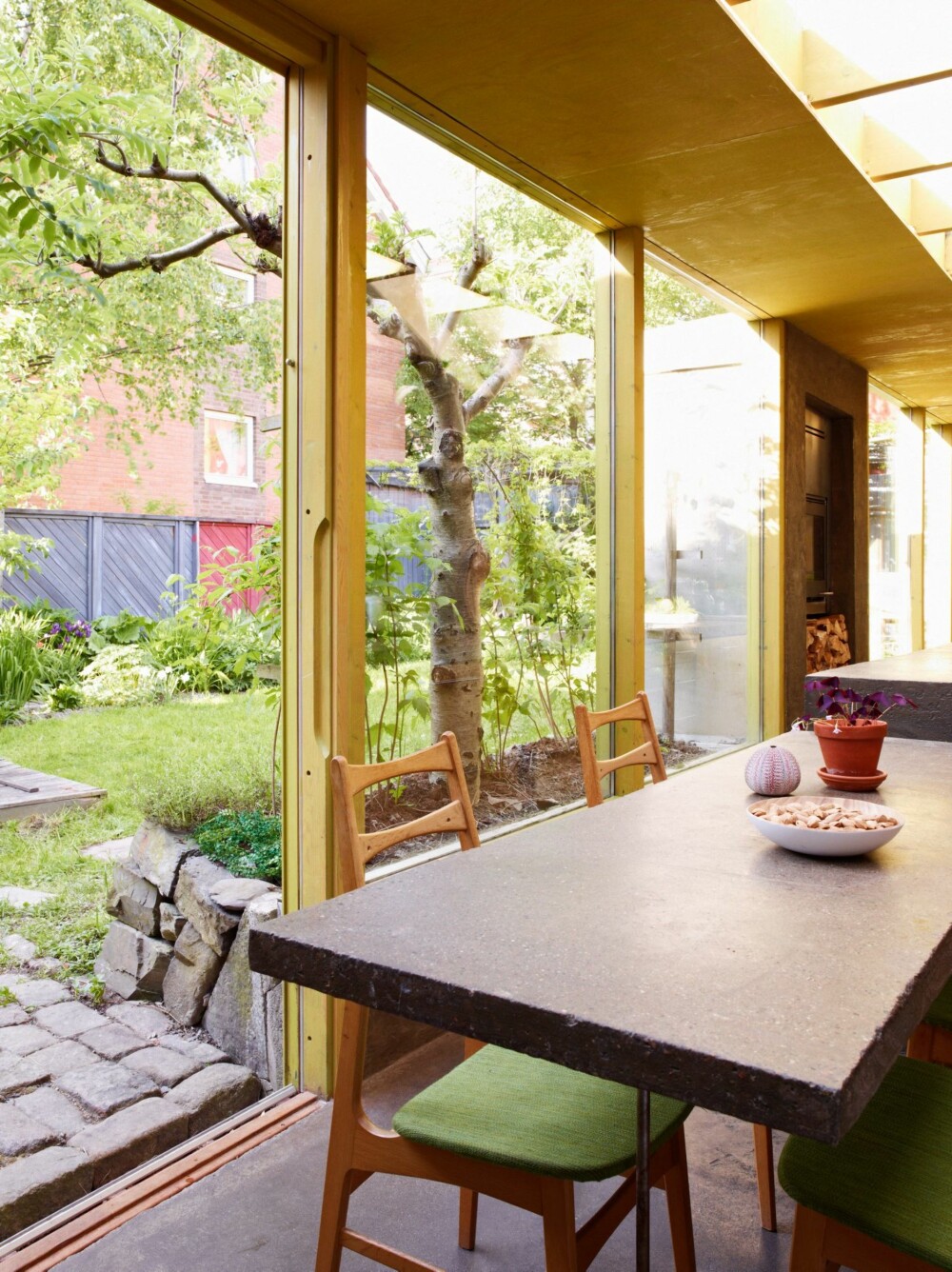 UTSYN MOT HAGEN: Tidligere var hagen et sted som lå utenfor huset. Tilbyggets store glassflater bidrar til at hagen integreres i boligen, som et ekstra rom. Nærkontakten med hagen gjør at det aldri føles trangt på kjøkkenet. UTSYN MOT HAGEN: Tidligere var hagen et sted som lå utenfor huset. Tilbyggets store glassflater bidrar til at hagen integreres i boligen, som et ekstra rom. Nærkontakten med hagen gjør at det aldri føles trangt på kjøkkenet.