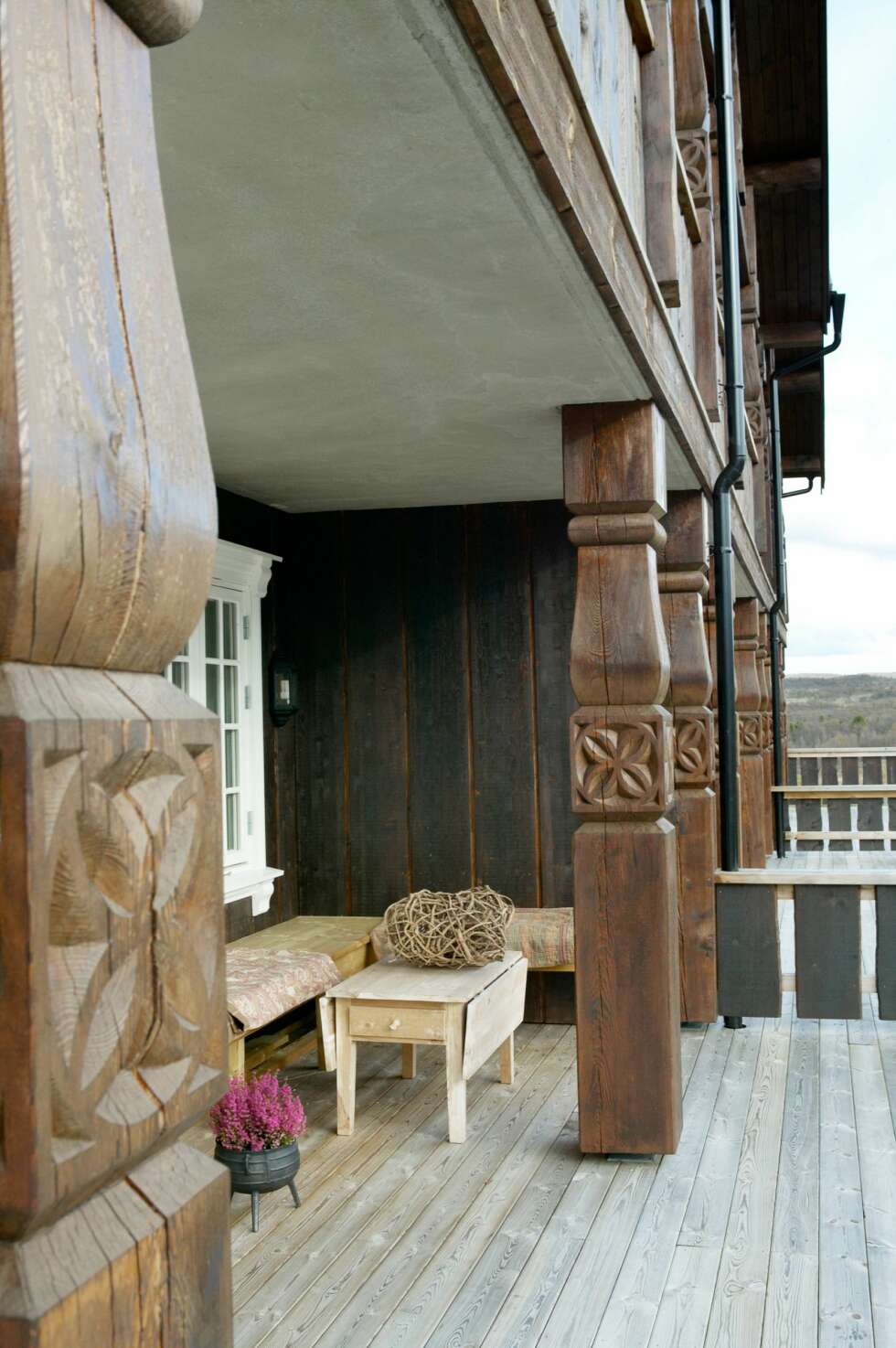 TRADISJON: Deler av terrassen ligger i le for vinden. Her er det innredet til en lesekrok med benk og tepper. Dekoren på stolpene og det brede, grove panelet går igjen i de fire leilighetskompleksene. TRADISJON: Deler av terrassen ligger i le for vinden. Her er det innredet til en lesekrok med benk og tepper. Dekoren på stolpene og det brede, grove panelet går igjen i de fire leilighetskompleksene.
