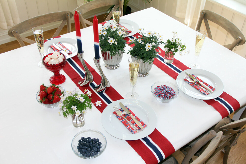 RØDT, HVITT OG BLÅTT: Du kan få kjøpt løpere i det norske flaggets farger. Disse er fra Princess. To margeritter i potter på bordet og to søte buketter med hvitveis gir skikkelig 17. mai-stemning. Lys og servietter fra Tilbords. Omaggio-vase fra Kahler og lysestakene Cobra fra Georg Jensen. RØDT, HVITT OG BLÅTT: Du kan få kjøpt løpere i det norske flaggets farger. Disse er fra Princess. To margeritter i potter på bordet og to søte buketter med hvitveis gir skikkelig 17. mai-stemning. Lys og servietter fra Tilbords. Omaggio-vase fra Kahler og lysestakene Cobra fra Georg Jensen.