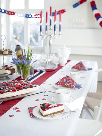 DELIKAT: Et lekkert 17. mai-festbord med løper over hvit duk. Her er det pyntet med løkblomster fra hagen og flaggservietter og lys fra Tilbords. DELIKAT: Et lekkert 17. mai-festbord med løper over hvit duk. Her er det pyntet med løkblomster fra hagen og flaggservietter og lys fra Tilbords.
