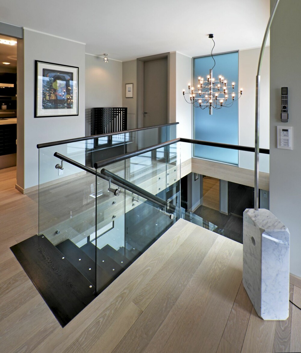 HØY PÅ DESIGN: Med et trapperom som åpner for lyset og et tilstøtende "glassgalleri" åpnes rommene for lyset. Italienske lampeklassikere og designmøbler kler rommet. Lys eik på gulvet. HØY PÅ DESIGN: Med et trapperom som åpner for lyset og et tilstøtende "glassgalleri" åpnes rommene for lyset. Italienske lampeklassikere og designmøbler kler rommet. Lys eik på gulvet.
